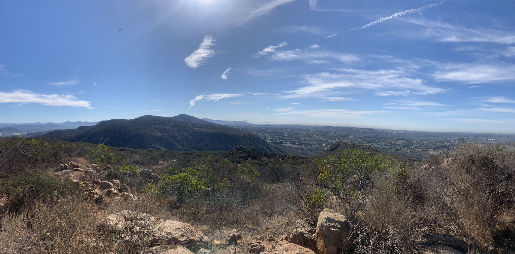 Panoramic view of sunlit mountains and a distant valley under a bright blue sky. - South Fortuna and North Fortuna Loop