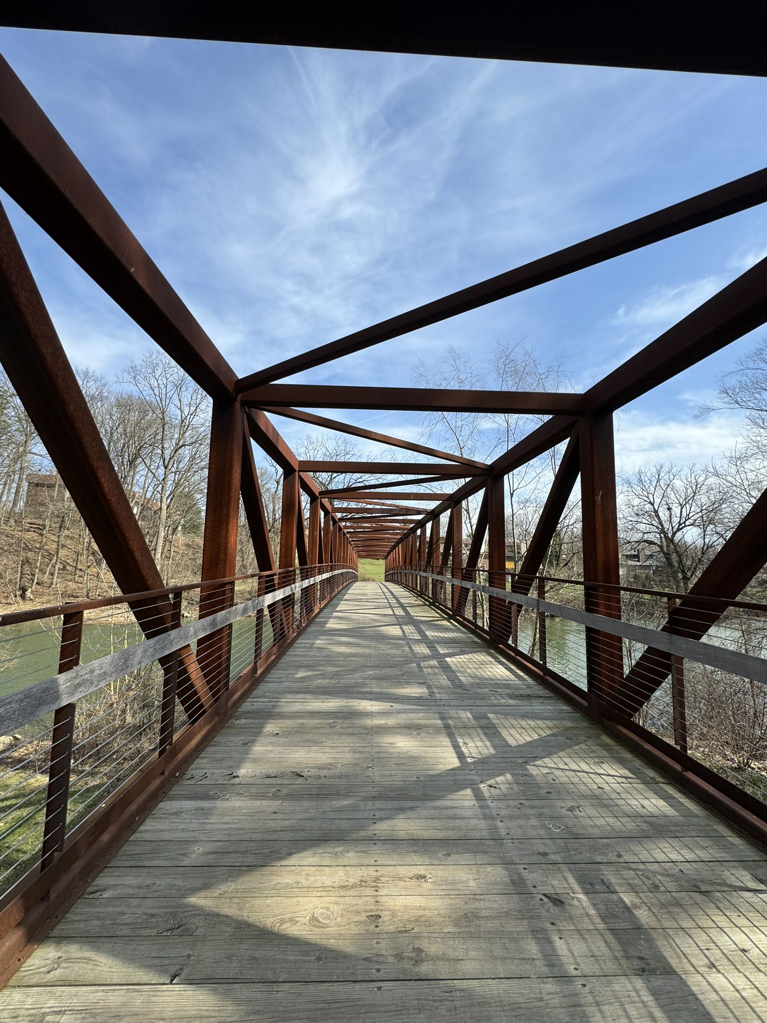 Looking down the wooden deck of a metal truss bridge under a bright sky. - Wehr Covered Bridge – Trexler Memorial Park loop from Allentown