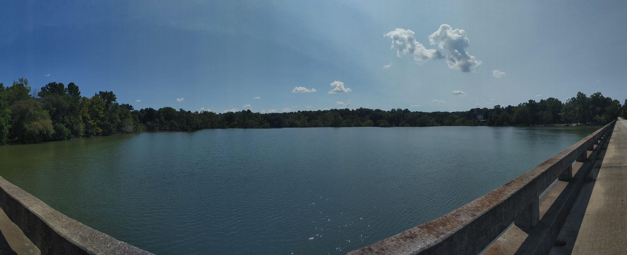 Panoramic view of a wide, calm lake from a bridge on a sunny day. - The Whistle Stop Café loop from Juliette