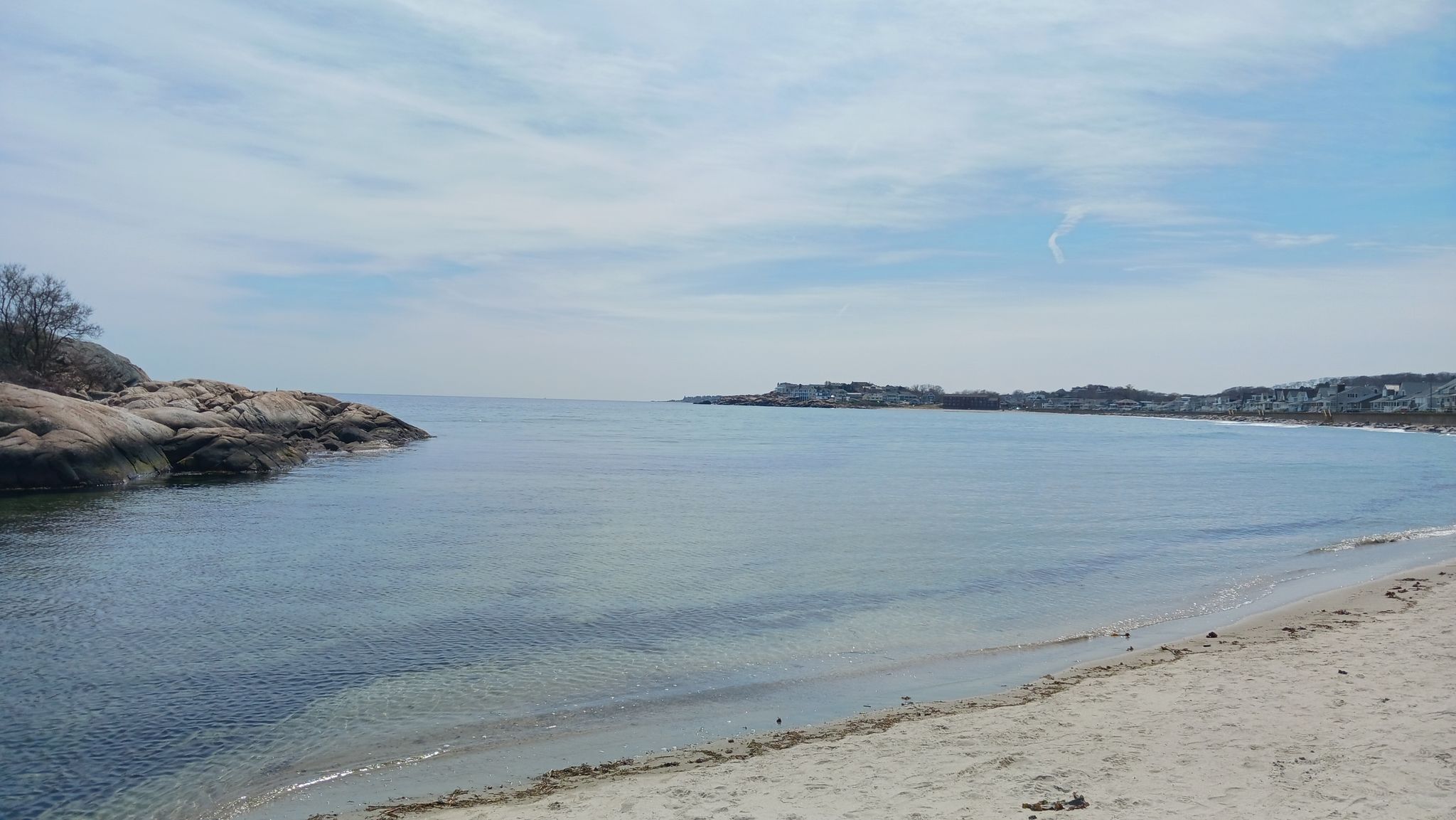 Calm ocean bay with sandy beach and rocky shore under a bright sky. - Long Beach and Cape Hedge Beach Trail