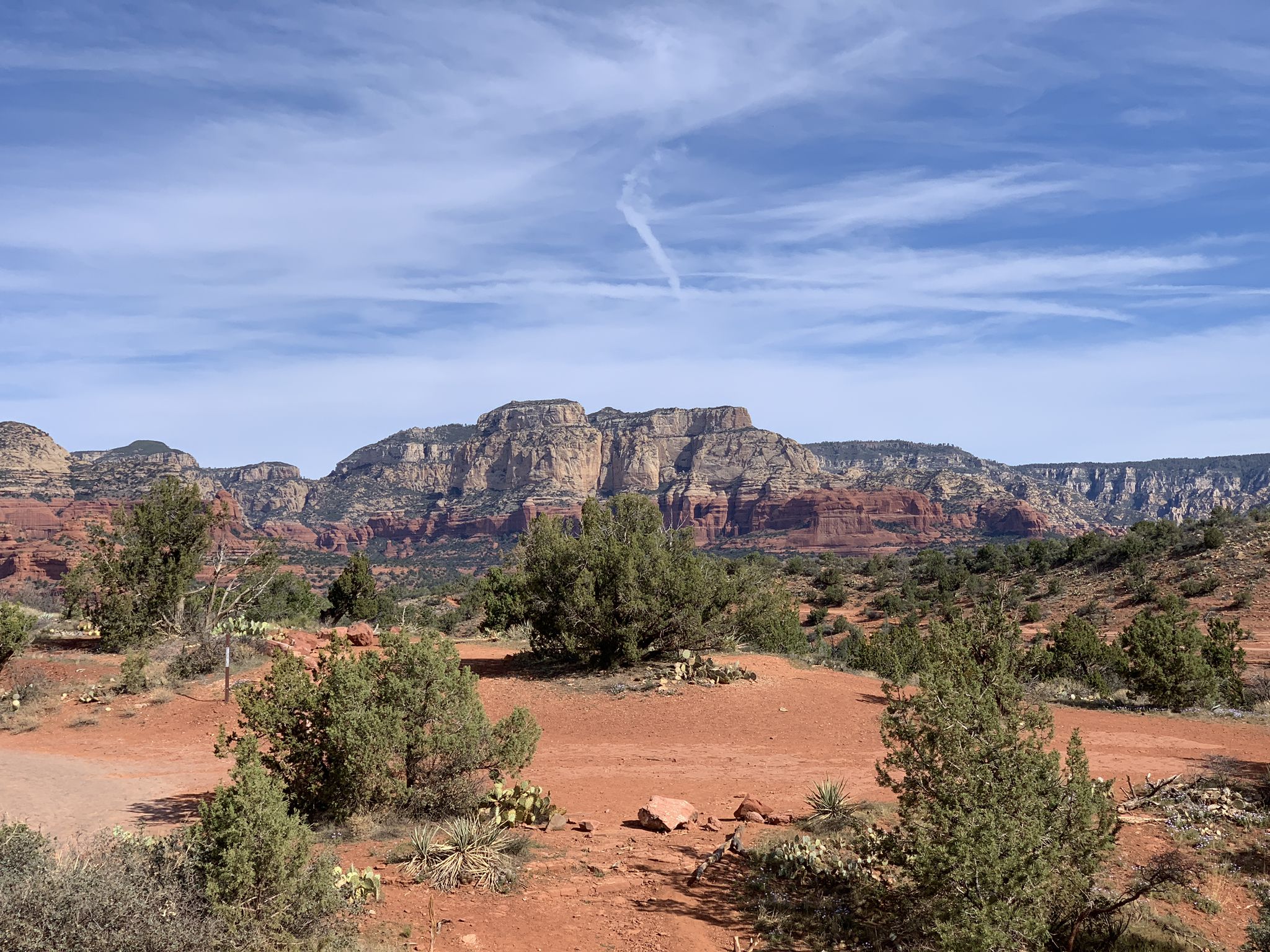 Expansive view of red rock mountains and green desert foliage under blue sky. - Canyon of Fools – MTB Trails in Sedona
