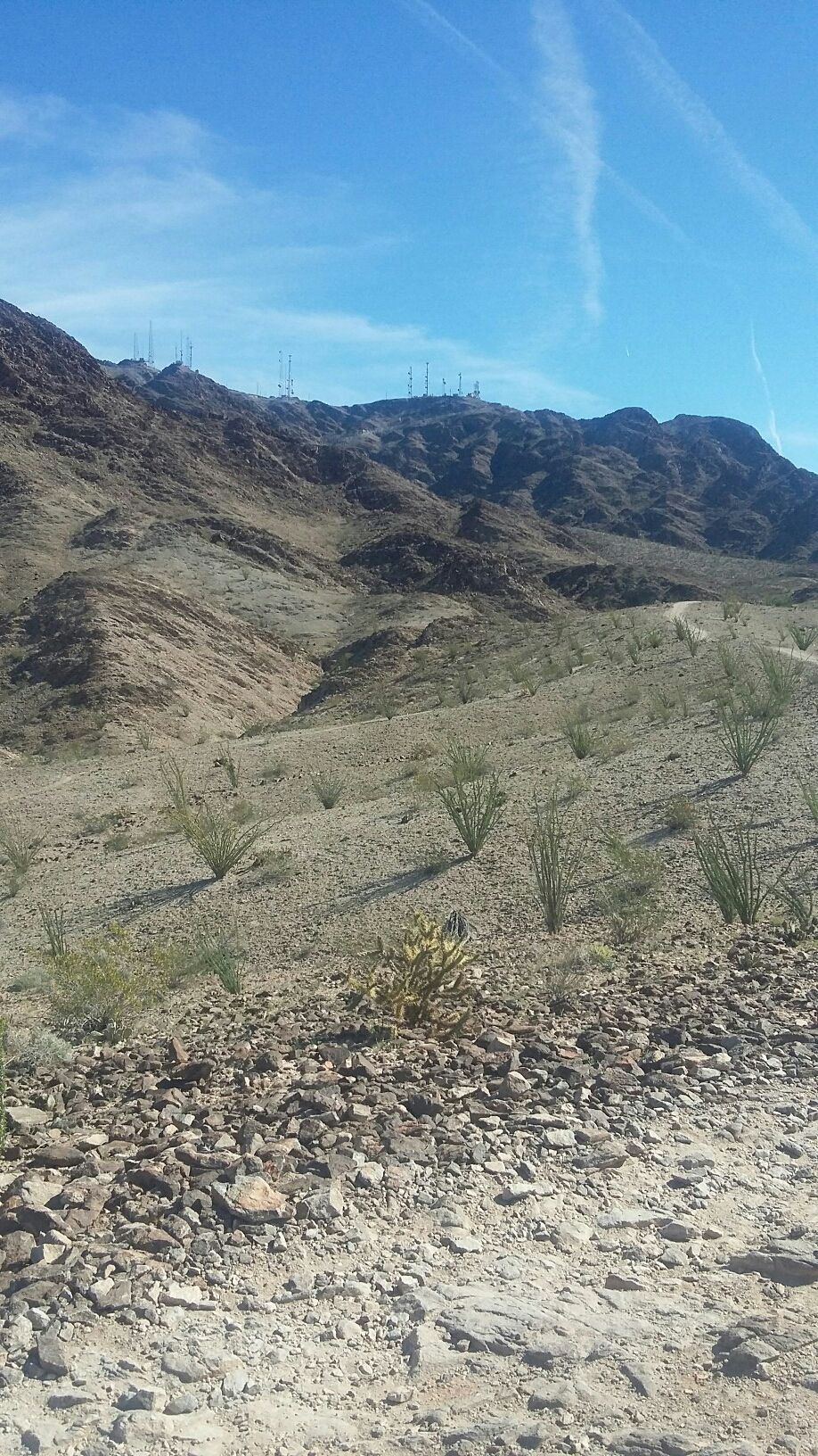 Arid mountain landscape with communication towers on distant peaks under a blue sky. - Long Telegraph Pass Loop