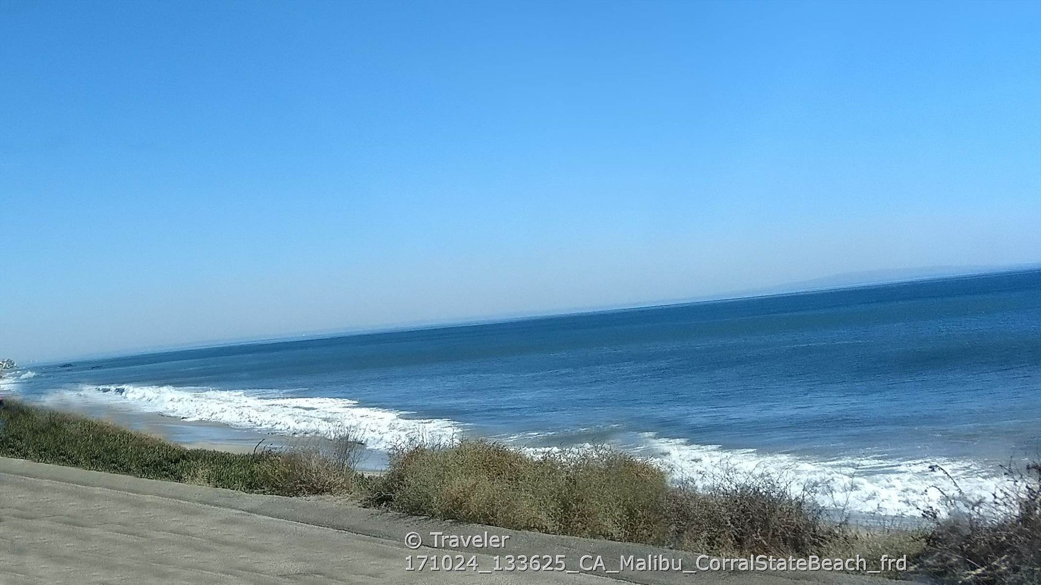 Expansive blue ocean with white waves breaking on a sunny sandy beach. - Latigo Canyon Loop