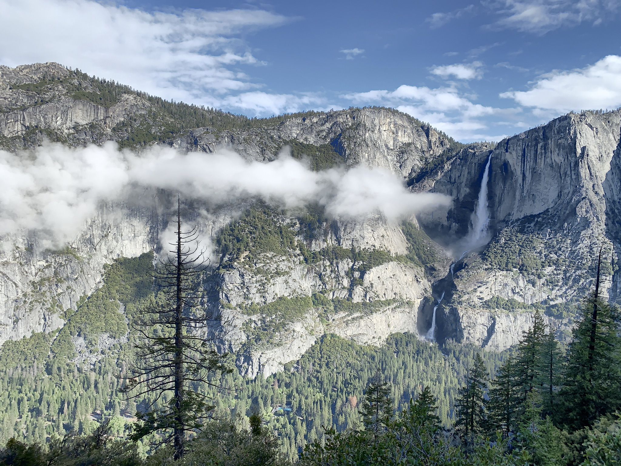 Majestic waterfall cascades down a rocky mountain face under a cloudy sky. - Four Mile, Panorama, and Mist Trail Loop