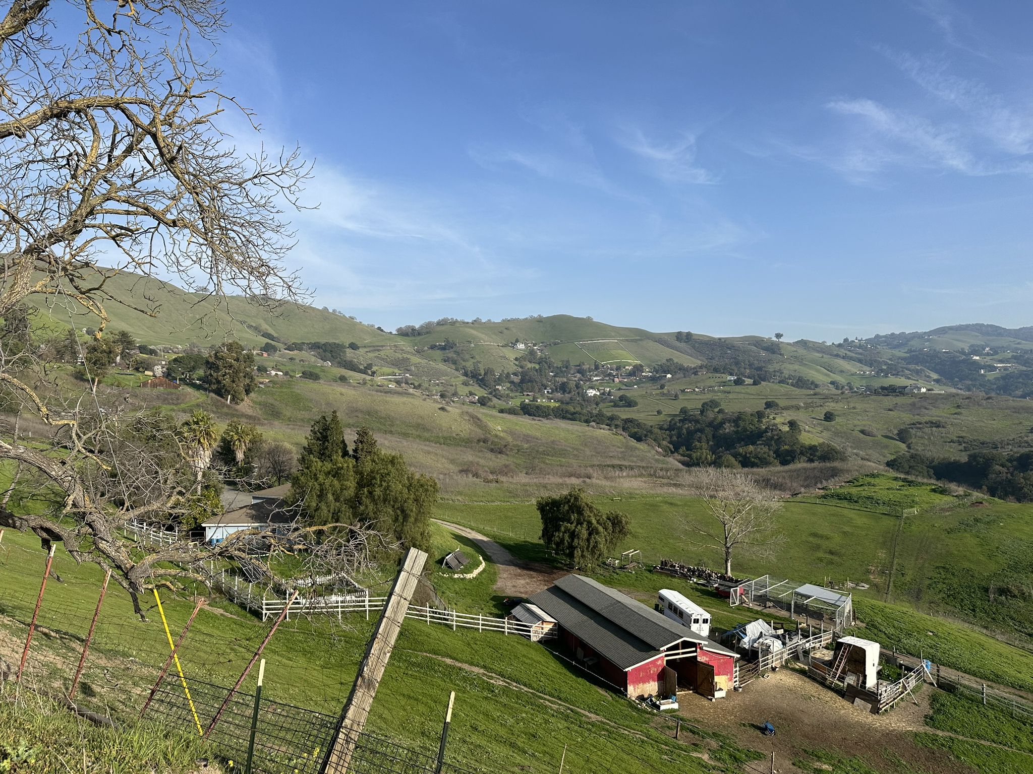 Green hills, a red barn, and distant houses under a clear sky. - Mount Hamilton & JD Grant Park loop from Berryessa