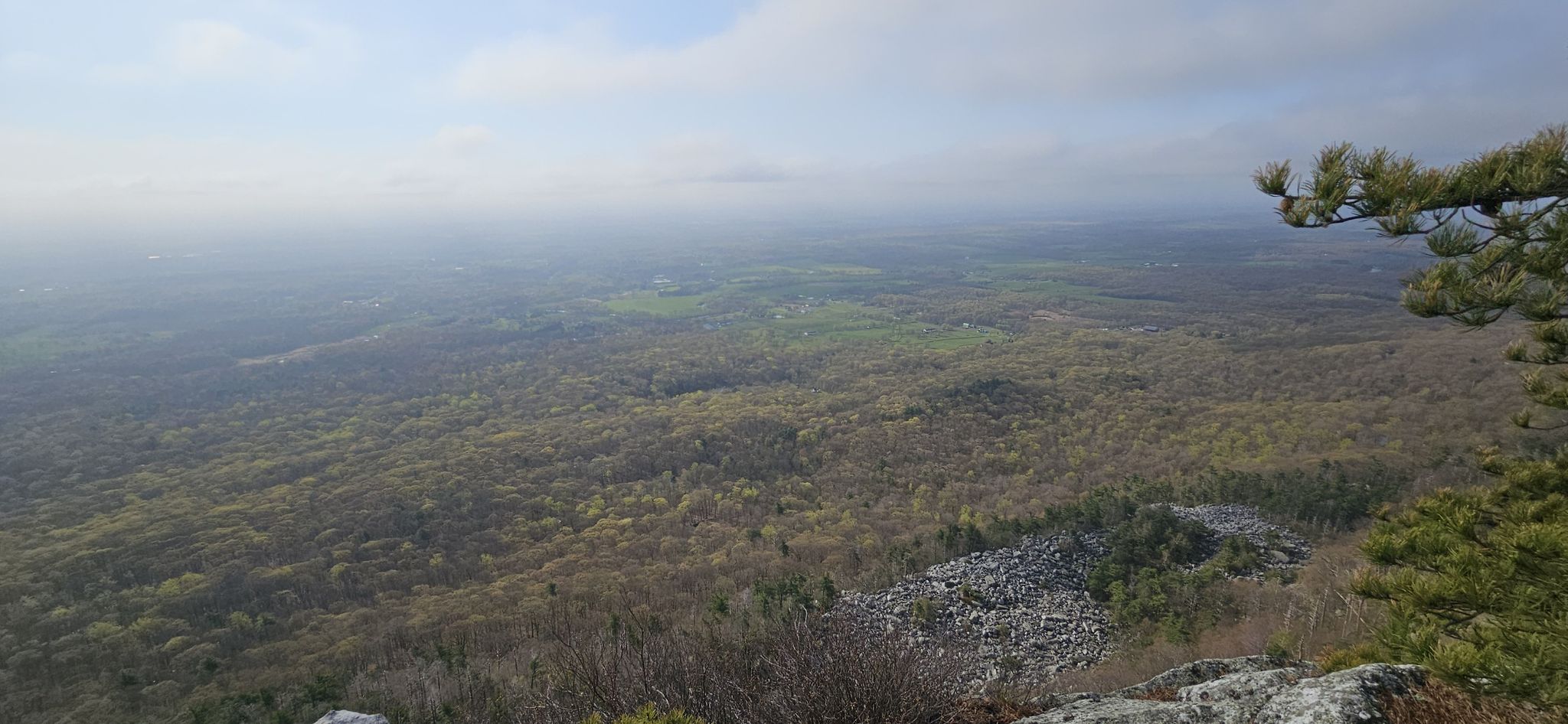Hazy panoramic view of a vast forested valley from a rocky cliff. - Millbrook Mountain via Trapps, Coxing, & Millbrook Ridge Trail loop