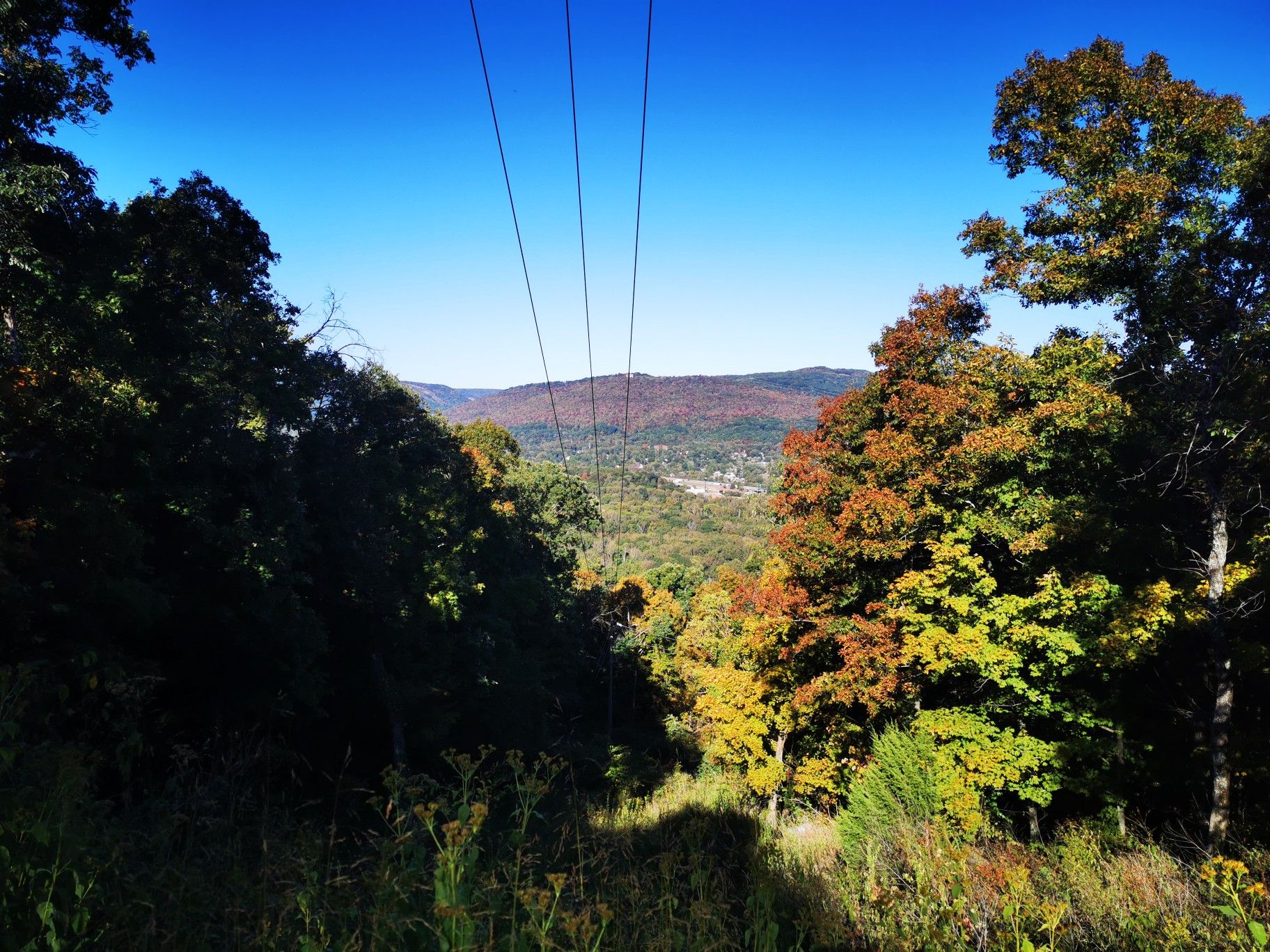 View from a wooded hillside overlooking a valley with autumn trees and clear sky. - Incline Rail crossing loop from St. Elmo's