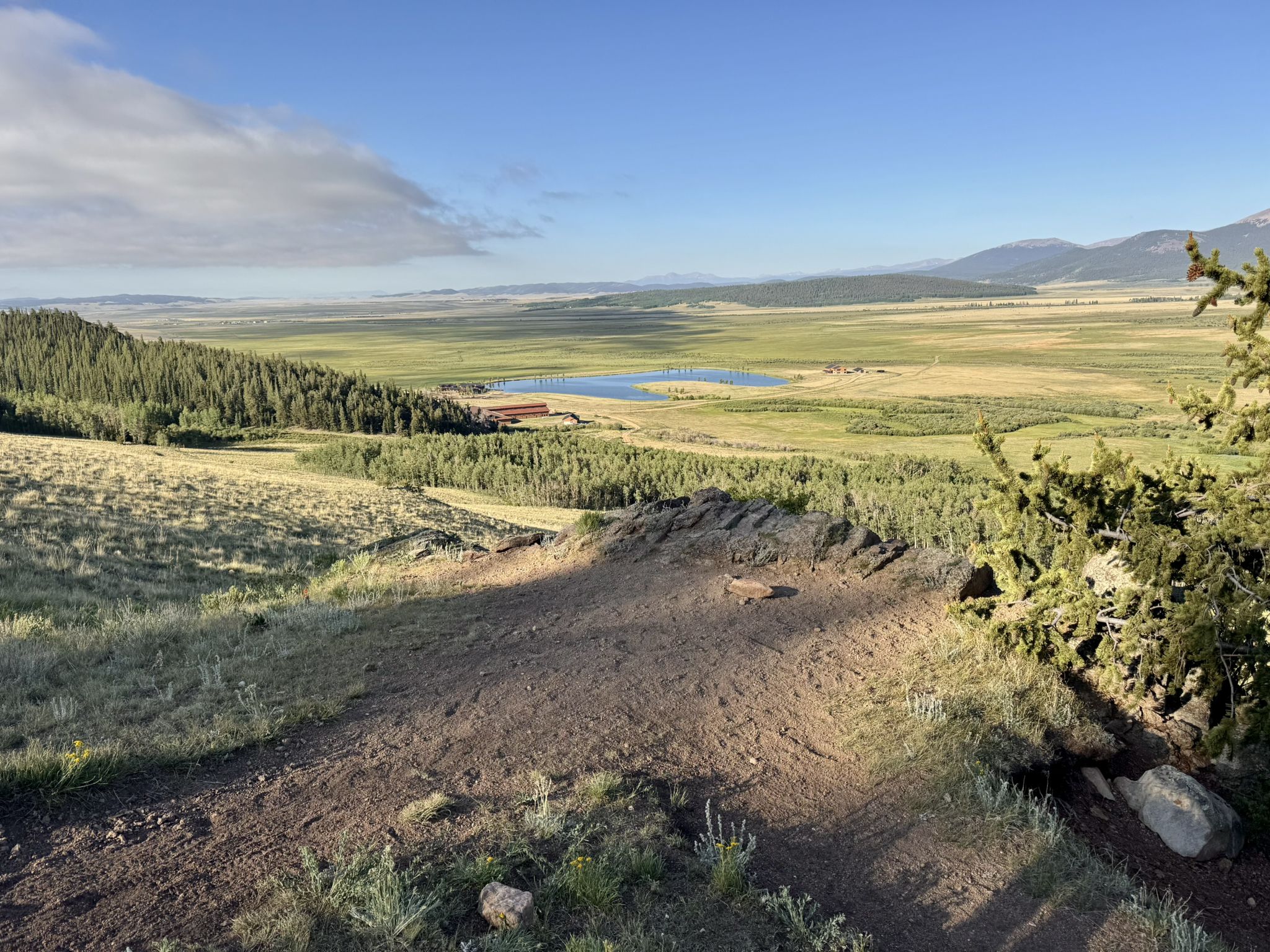 Expansive valley with a lake, forest, and distant mountains under a bright sky. - Colorado Trail: Segment 6