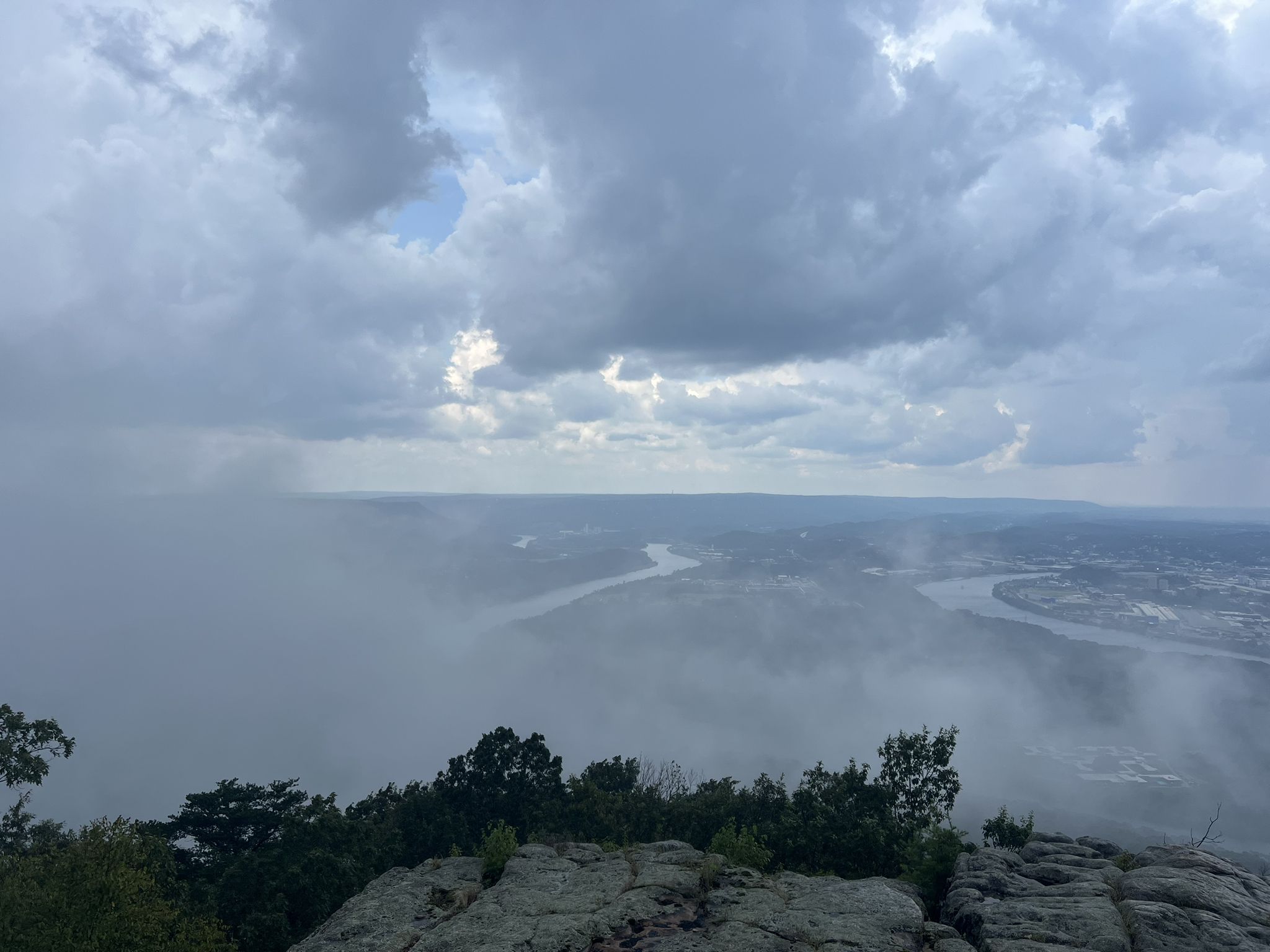 Overcast sky above a misty valley with a winding river and distant city. - Mountain Beautiful and Hardy Trail Loop