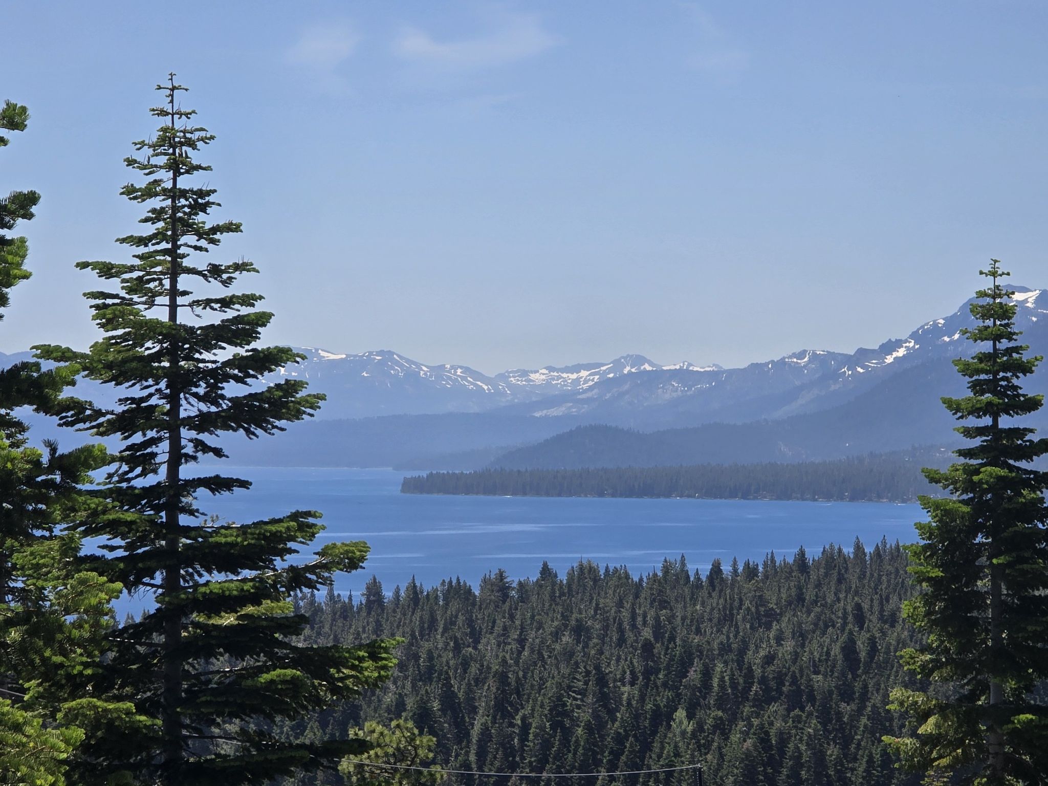 Large blue lake and snowy mountains framed by tall pine trees. - Tahoe Rim Trail (Glass Mountain) to Twin Crags