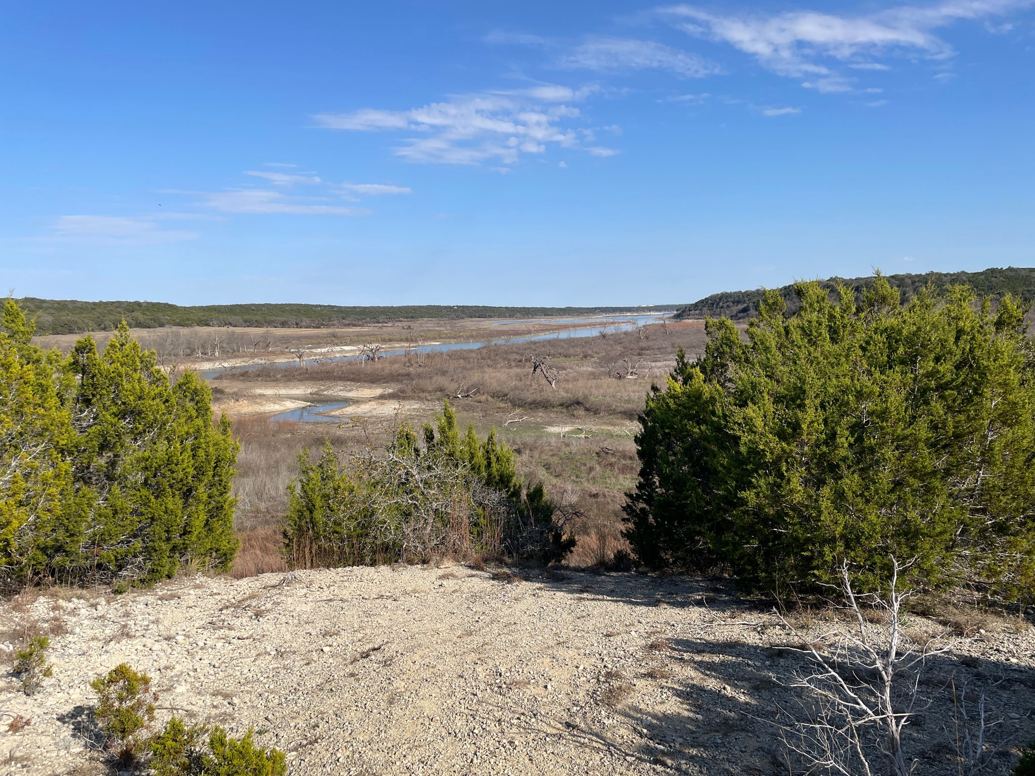 Wide river valley with green trees and a winding river under a blue sky. - Good Water Trail Loop