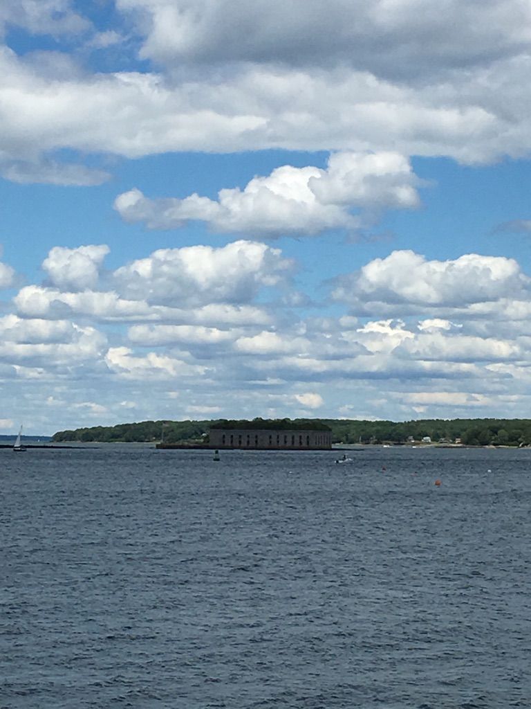 Distant stone fort across blue water under a cloudy sky. - Bug Light Park – Red's Dairy Freeze loop from South Portland