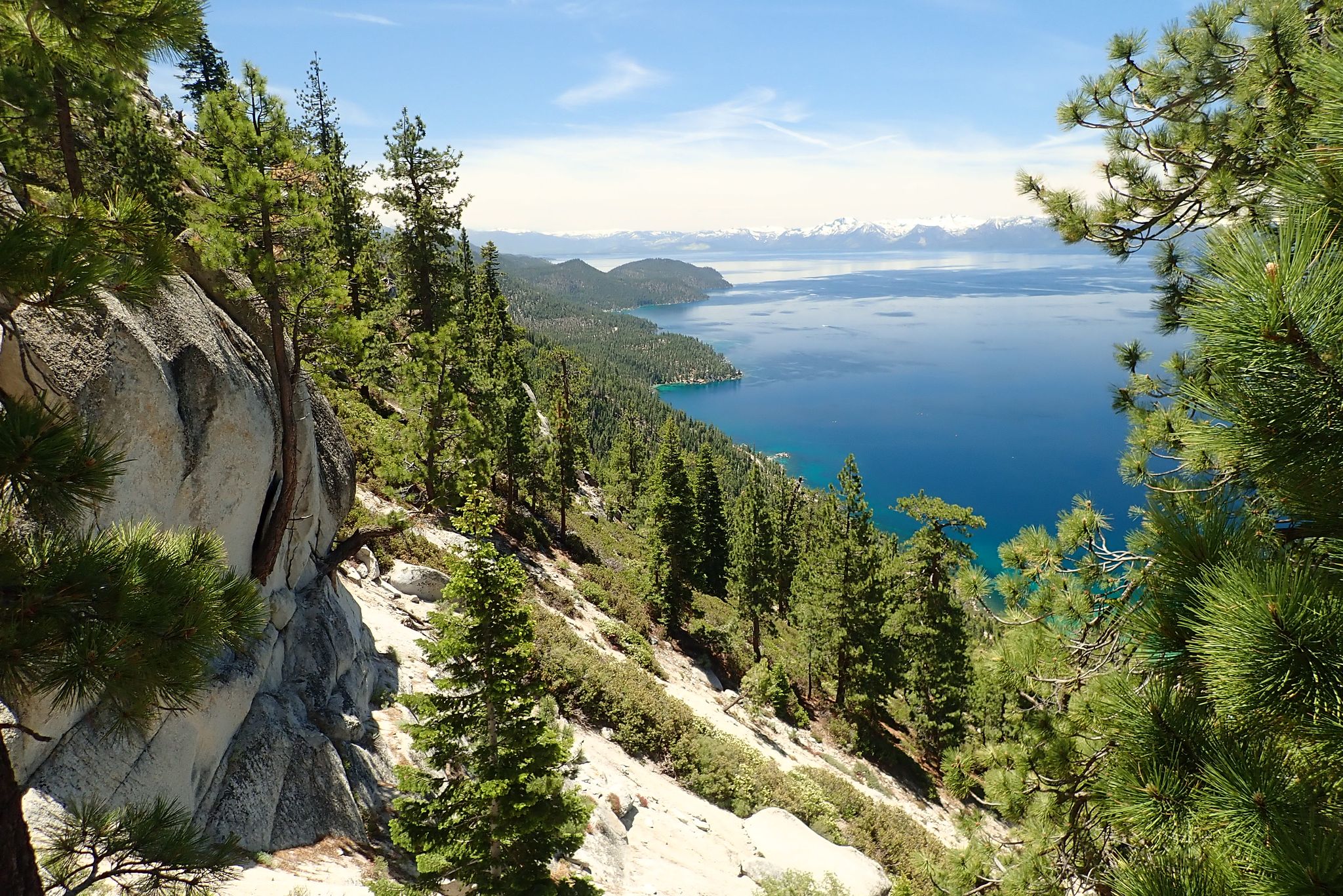 Bright sunny view of a large blue lake surrounded by pine forests. - Flume Trail and Tahoe Rim Trail Loop