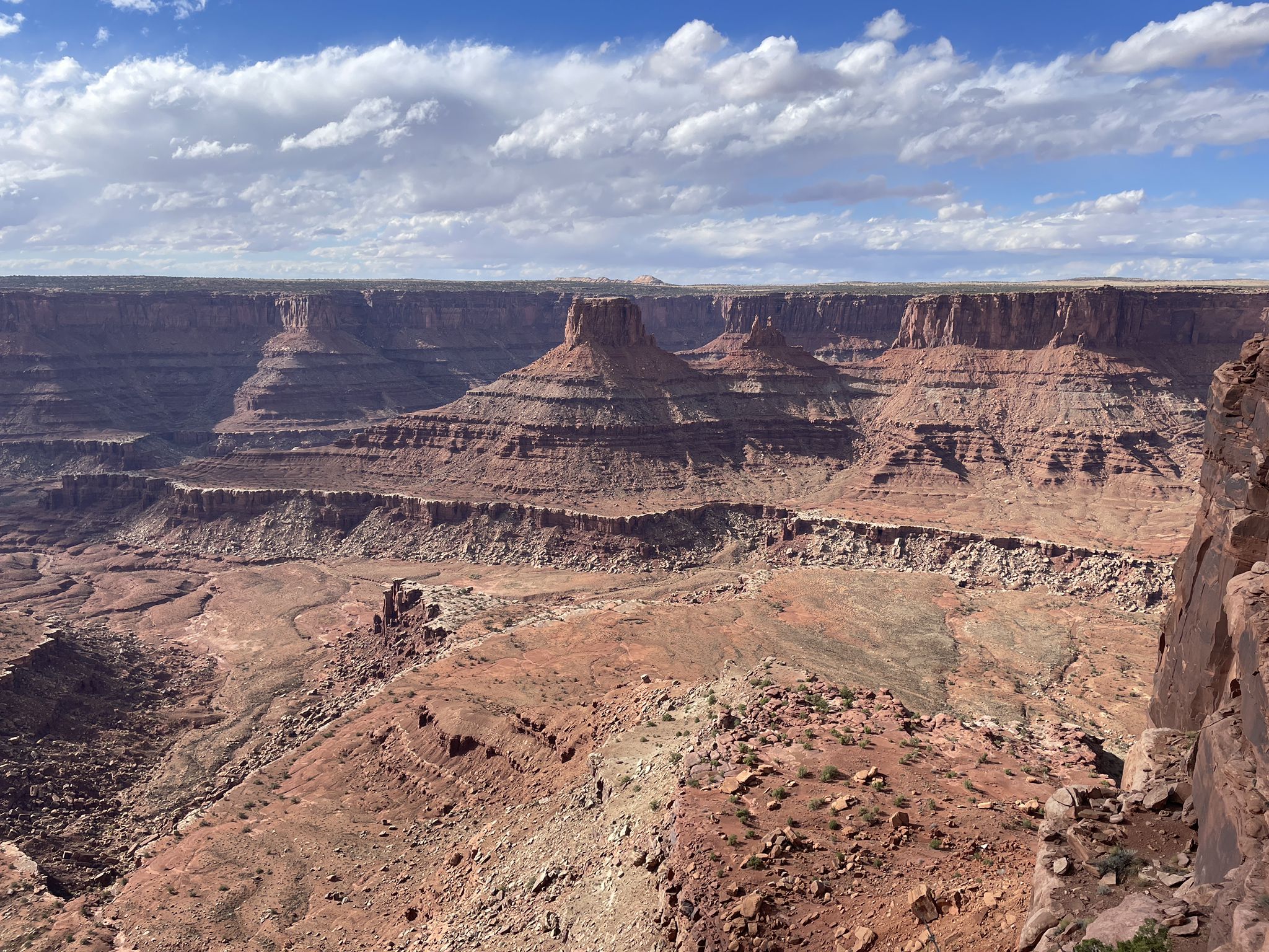 Deep red rock canyon with layered formations under a partly cloudy sky. - Shafer Canyon Overlook – Meander Overlook loop from Site 56
