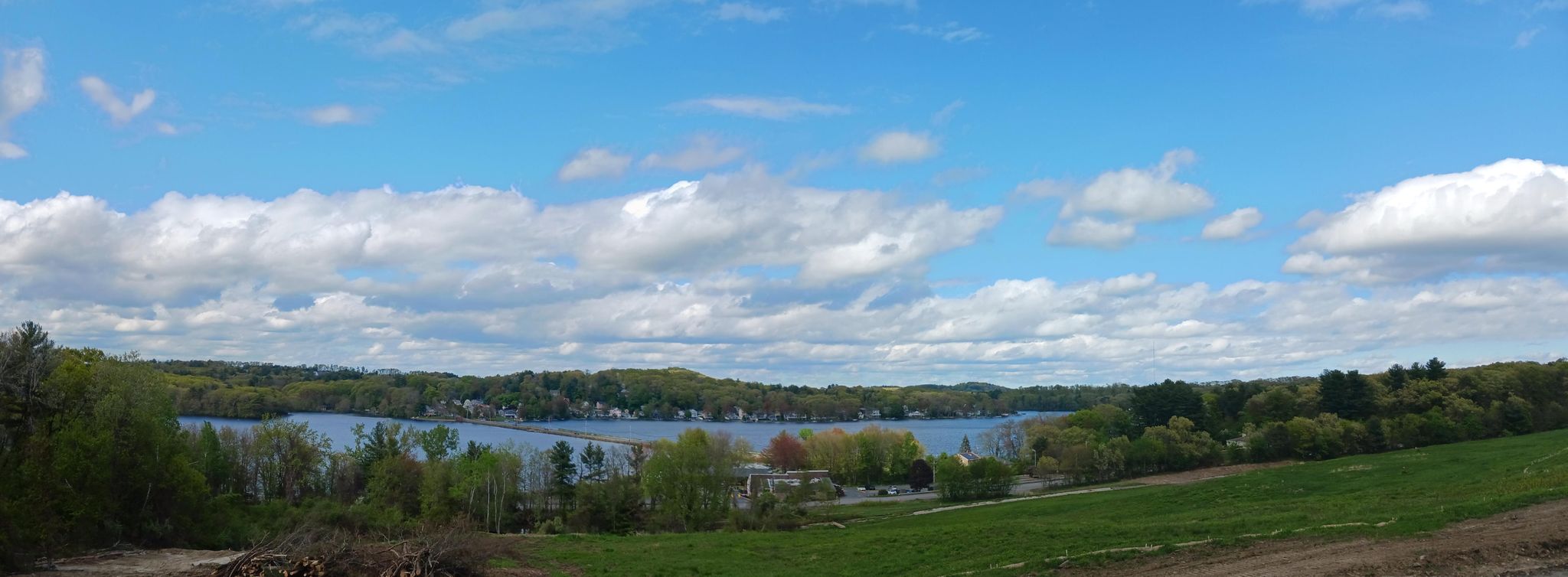 Sunny panoramic landscape with a lake, green trees, and a partly cloudy sky. - Assabet River Rail Trail and Callahan Park Loop