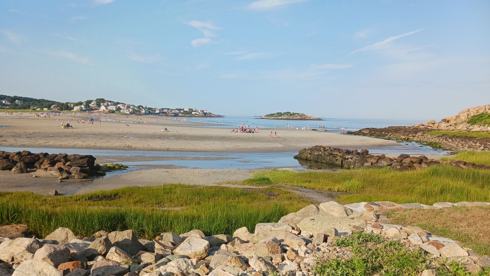 Sunny coastal scene with a sandy beach, tidal river, and distant town. - Rocky Neck Art Colony – Good Harbor Beach loop from Manchester