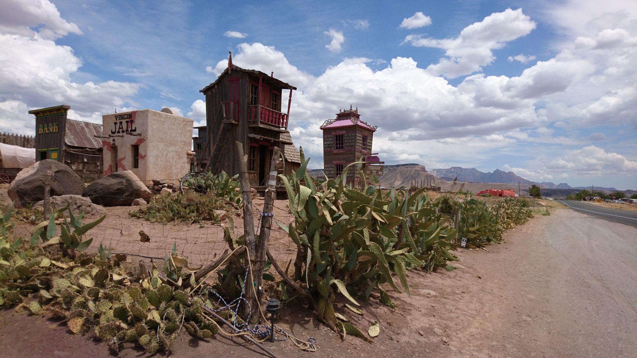 Old Western buildings and cacti under a bright, cloudy desert sky. - Hurricane, Utah to Lava Point Road