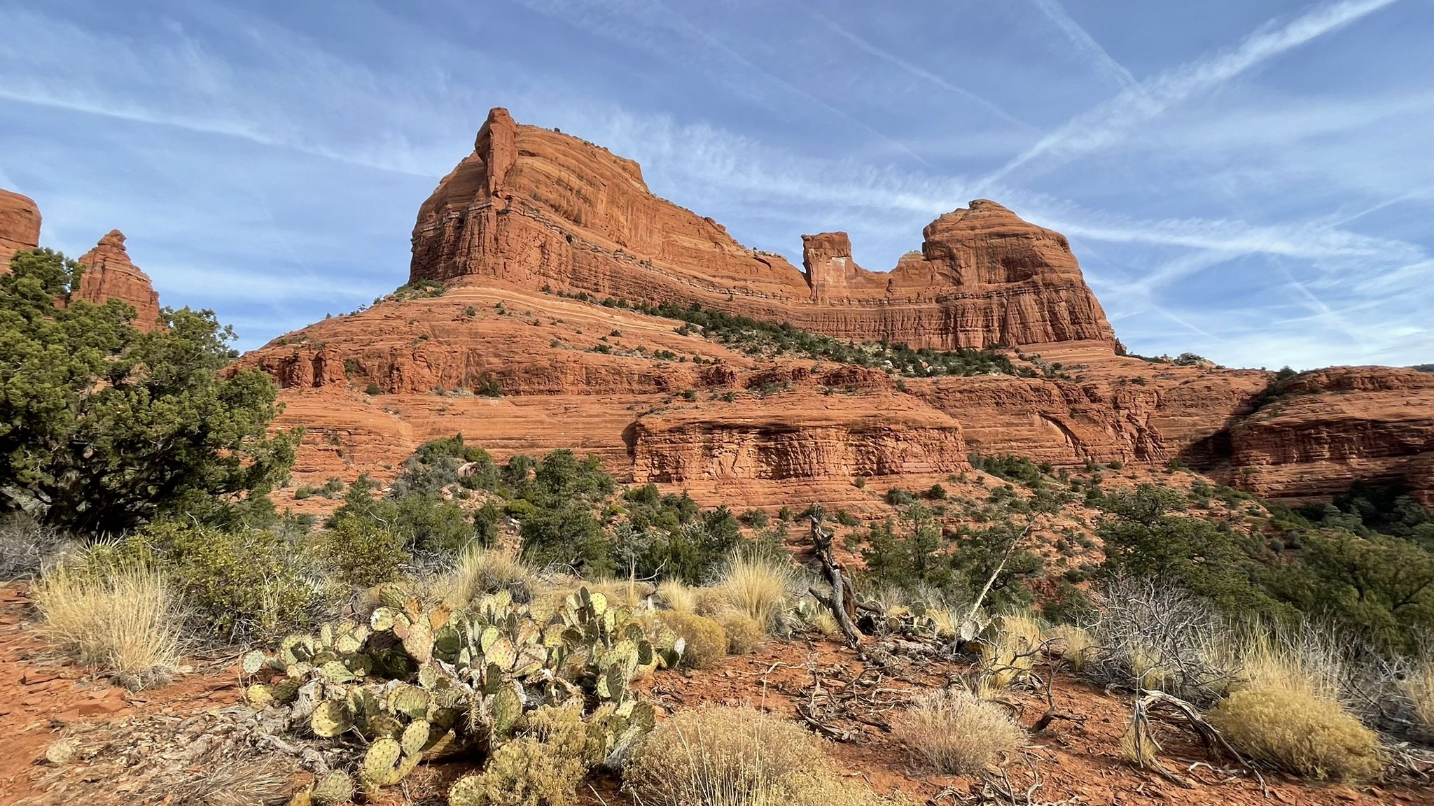 Towering red rock formations under a blue sky with desert plants. - Hangover – MTB Trails in Sedona