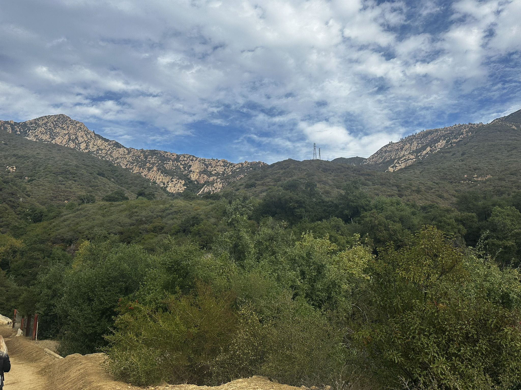Lush green mountains with rocky peaks under a partly cloudy blue sky. - Arlington Peak and Cathedral Peak Loop