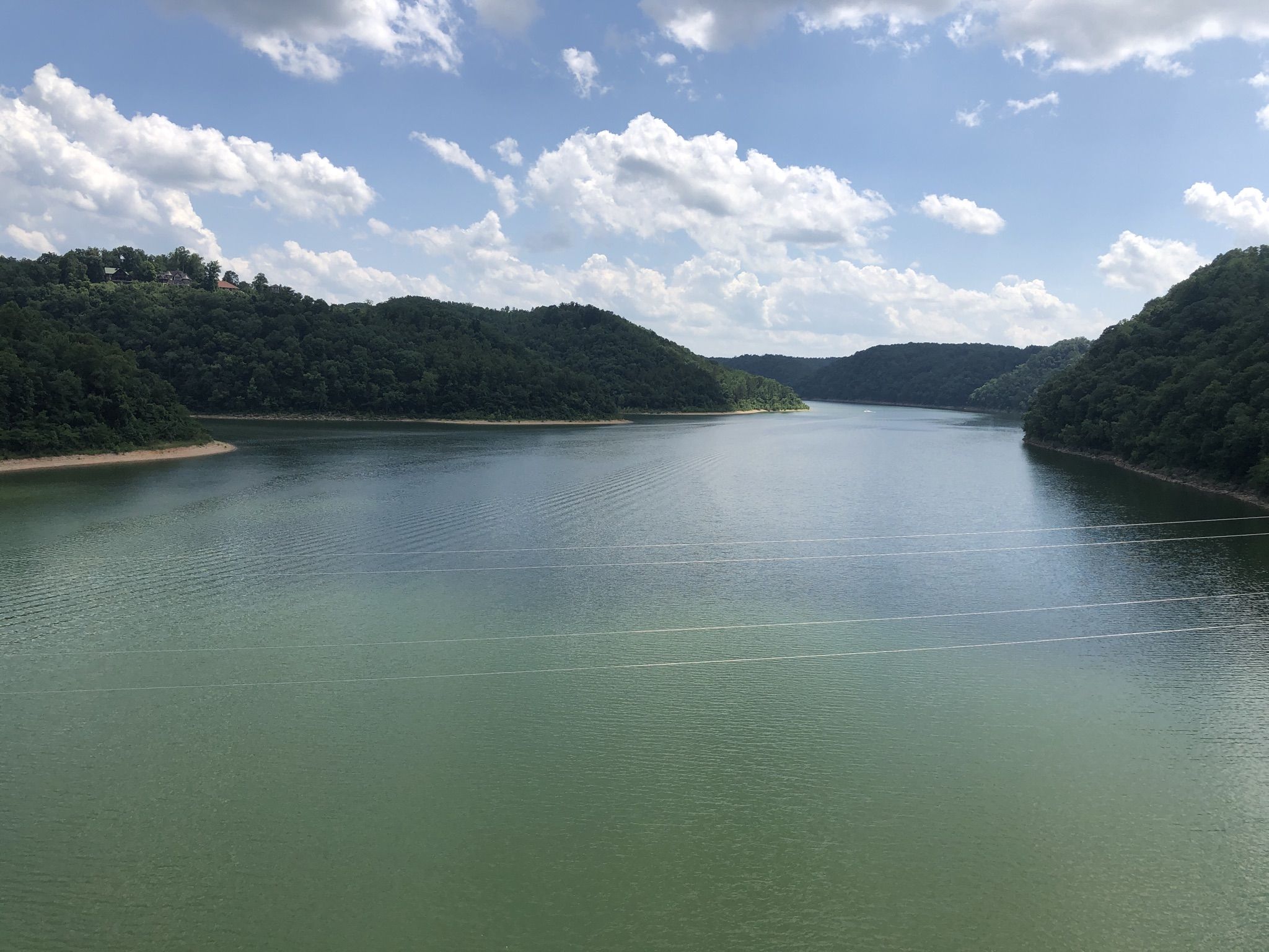 Wide lake surrounded by lush green hills under a partly cloudy sky. - Fall Creek Falls State Park to Rock Island State Park loop