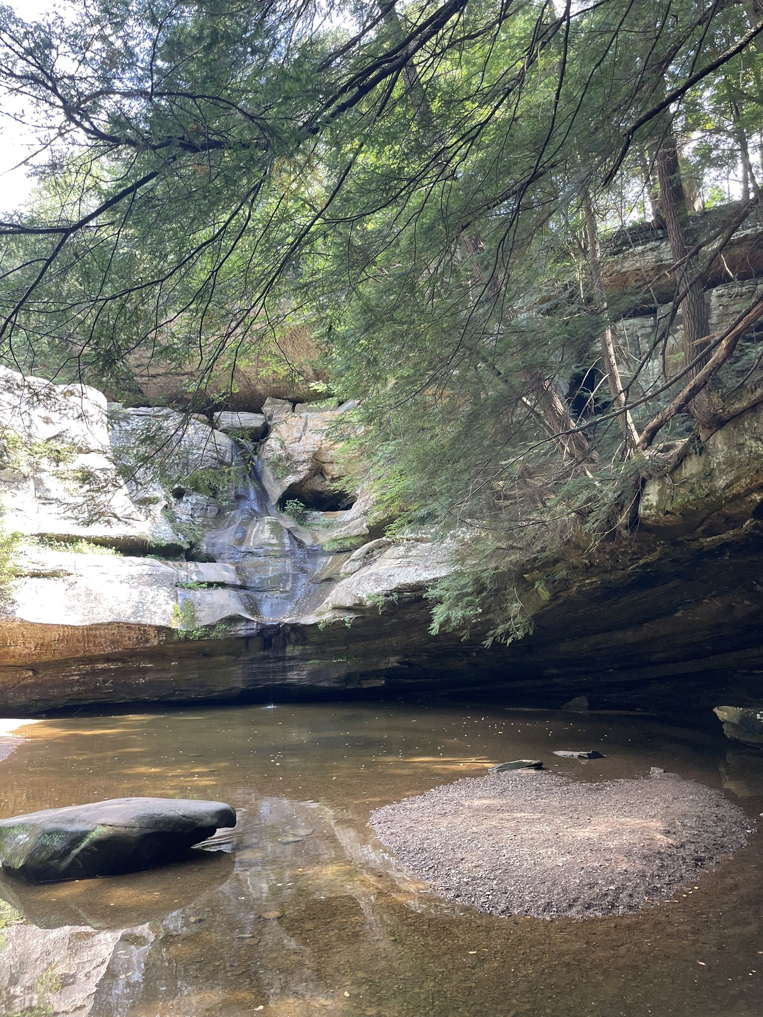 Small waterfall cascading into a rocky pool surrounded by trees. - Gorge Overlook Trail