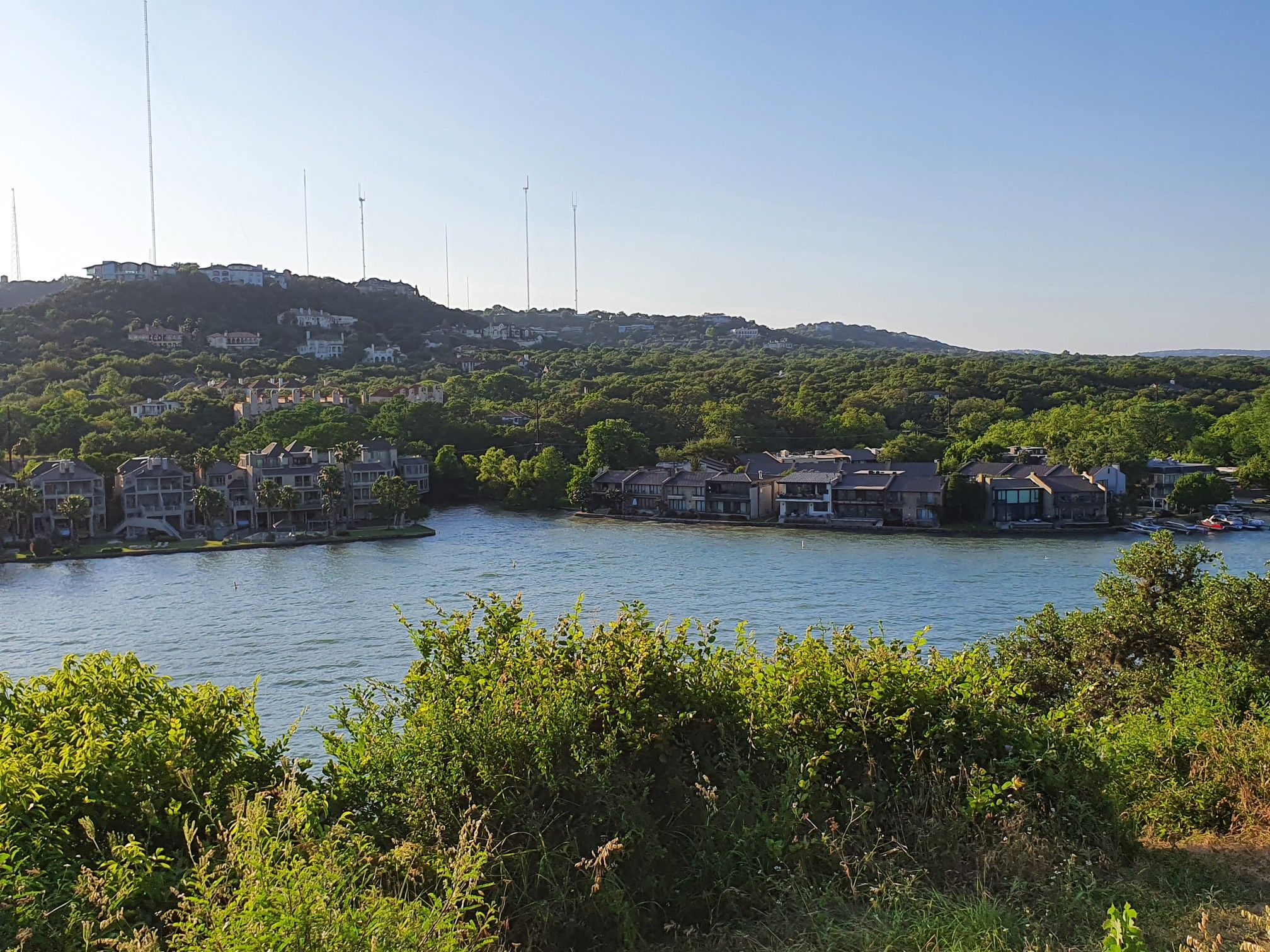 Bright daylight over a lake with houses nestled among green, wooded hills. - Mellow Johnny's Early Morning Tuesday loop