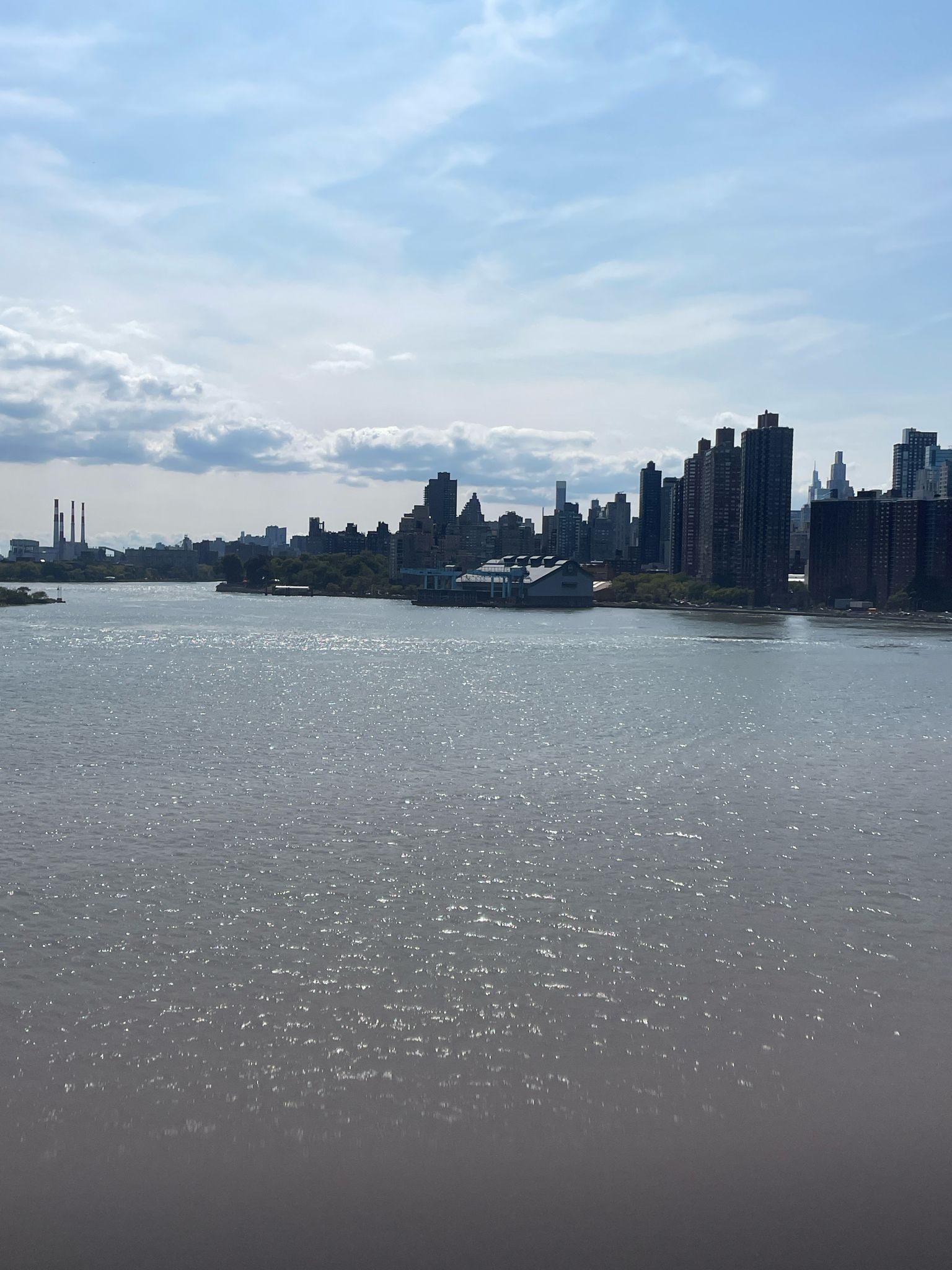 Wide river with a distant city skyline under a partly cloudy sky. - Center Drive, Central Park – Randall's Island Connector loop from Zerega Avenue