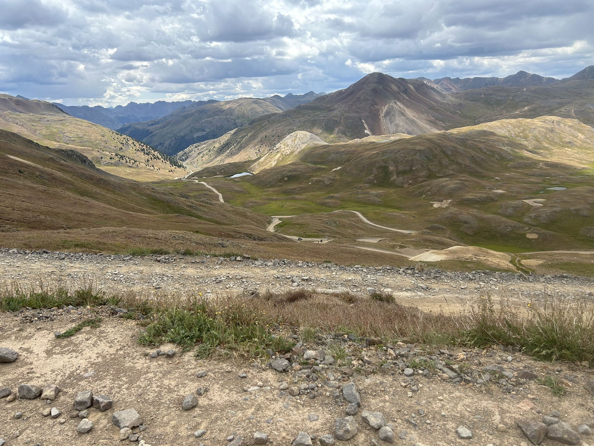 Expansive mountain landscape with winding dirt roads under a cloudy sky. - The Alpine Loop from Lake City