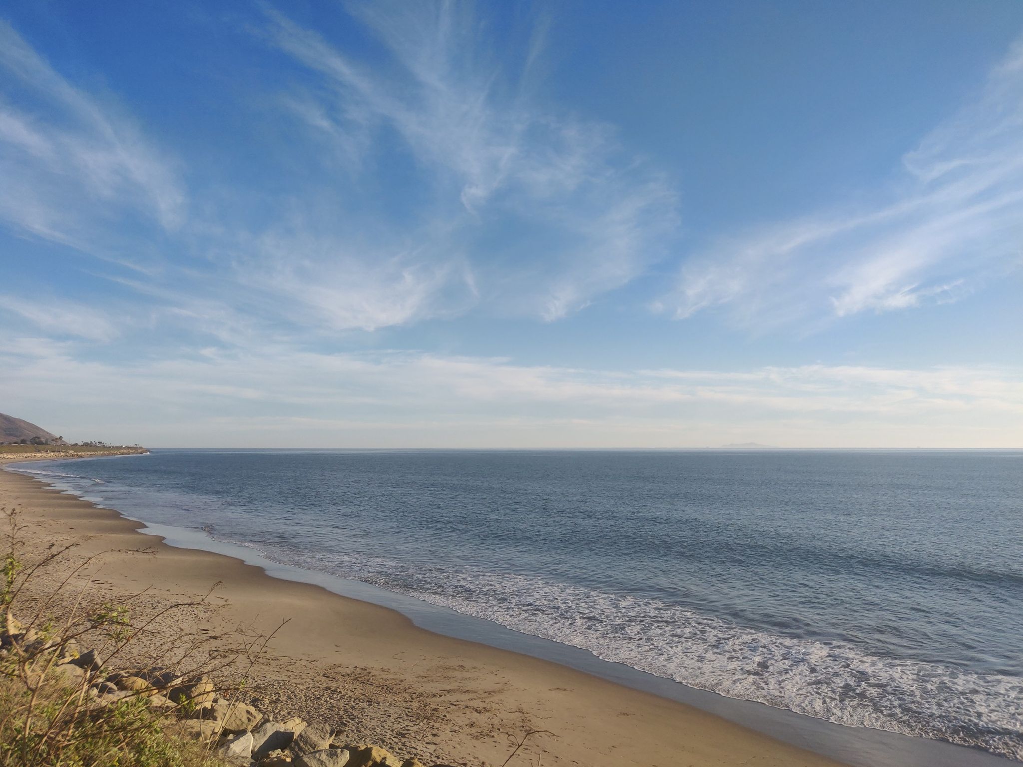 Wide sandy beach and ocean waves under a vast blue sky. - Lake Casitas loop
