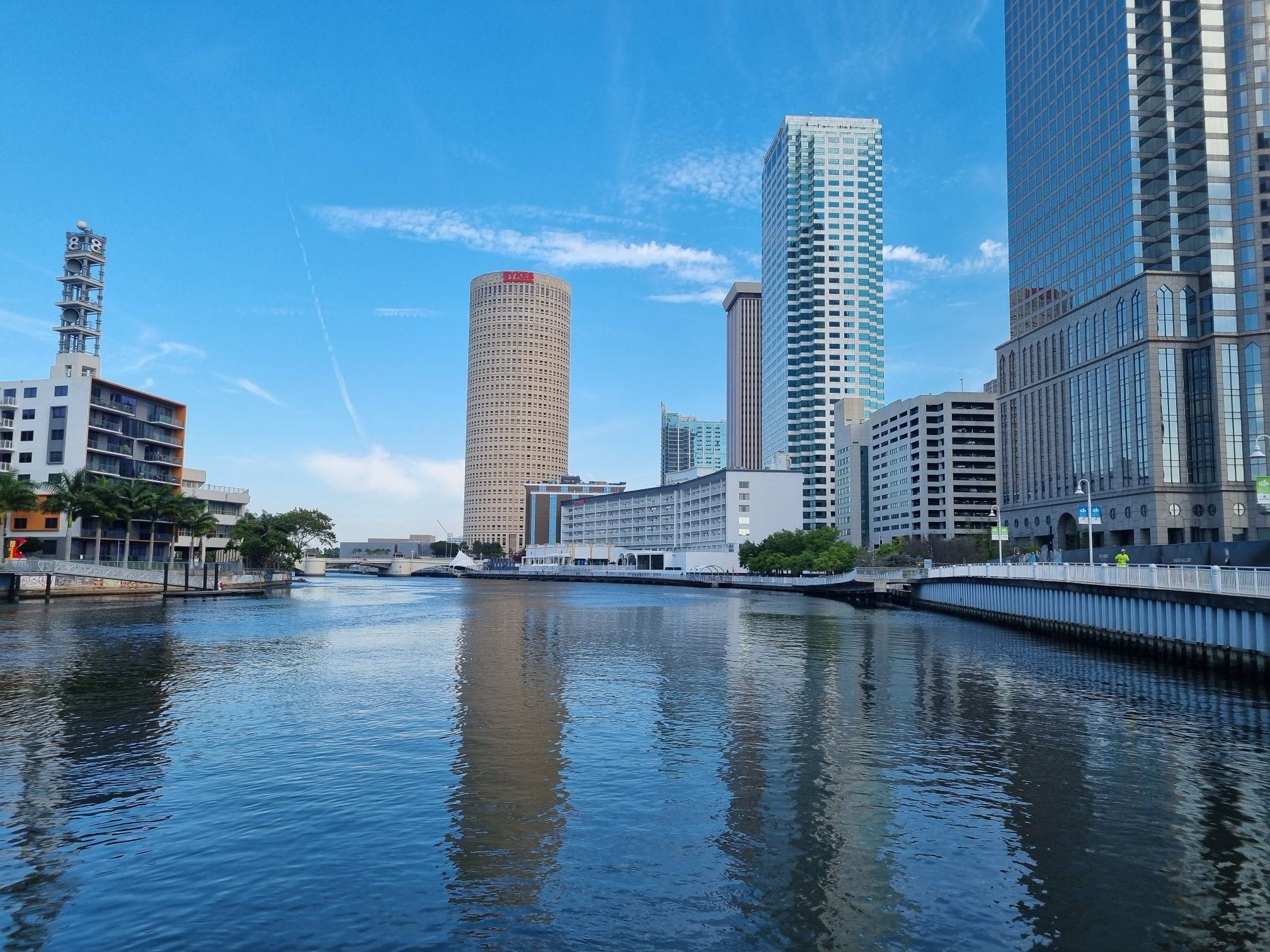 Tall city buildings reflecting in the calm river under a clear blue sky. - Davis Island Trail – Bayshore Linear Park loop from Tampa