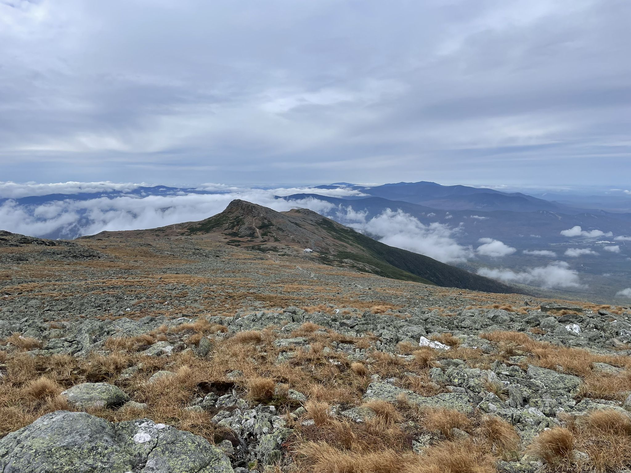Overcast sky above rocky mountain peaks and distant cloud-covered valleys. - Mount Washington Summit Loop Trail