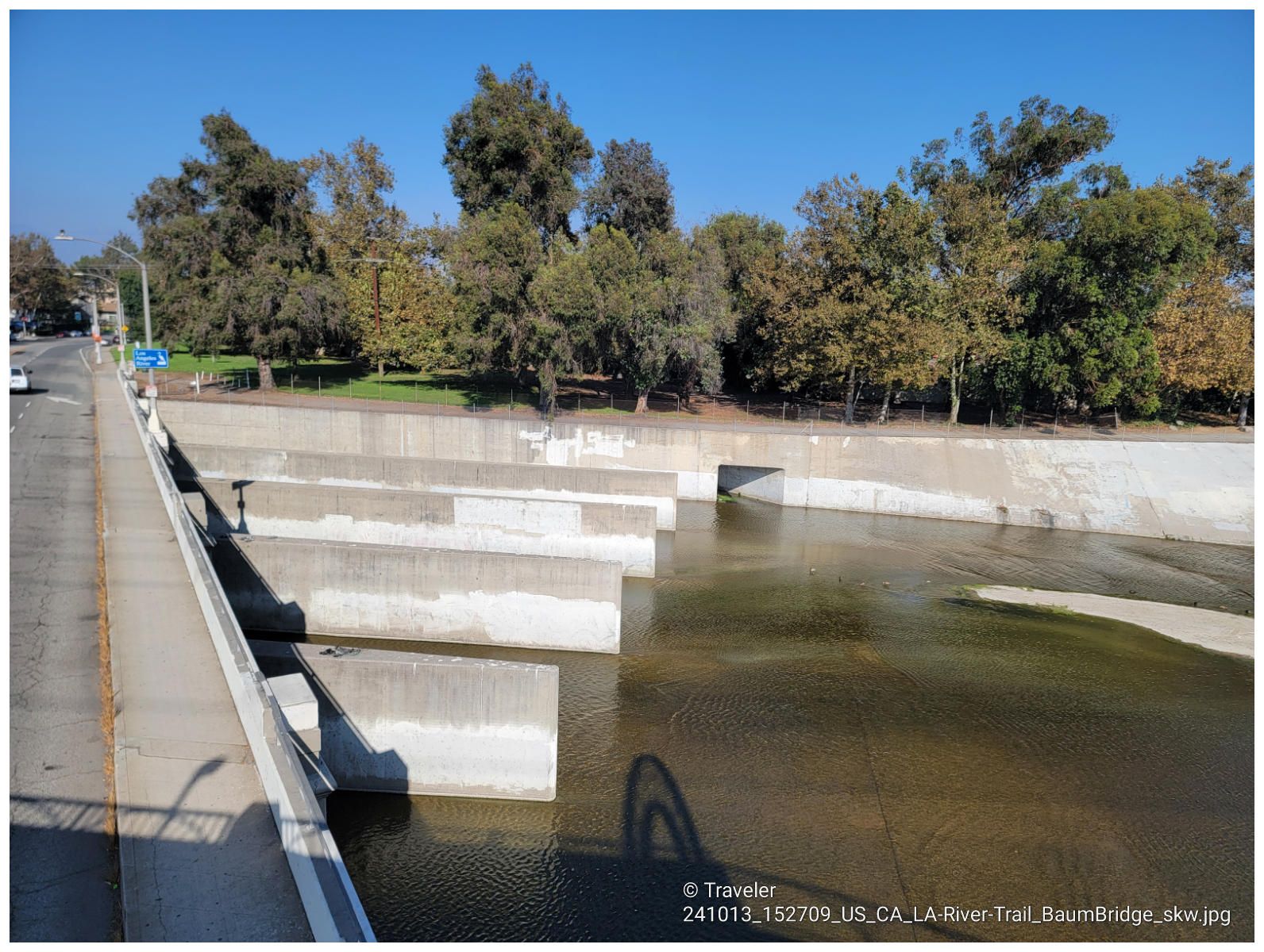 Concrete river channel with water flowing past large concrete structures. - Eagle Rock loop