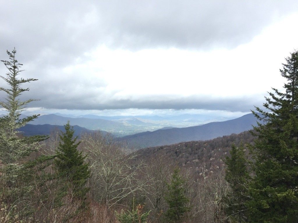 Wide view of distant mountains and a valley under a cloudy, gray sky. - Balsam Gap Overlook to Richland Balsam Overlook