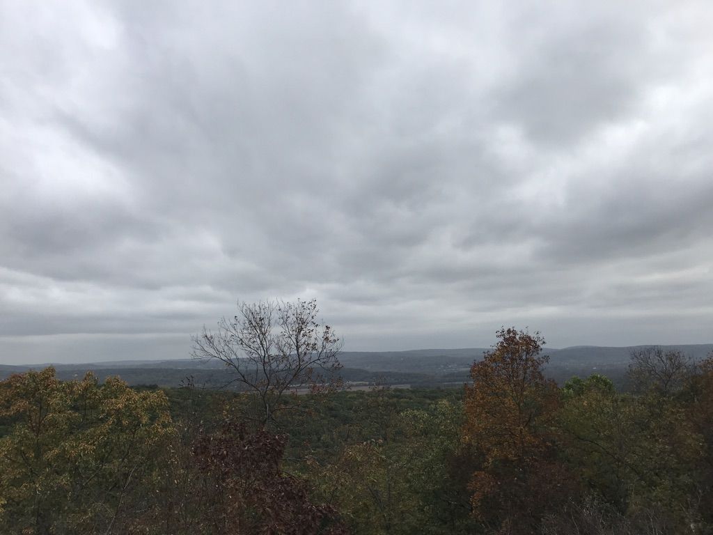Overcast sky above a wide forested landscape with distant hills. - Swamp, Summit, and Ghost Lake Trail