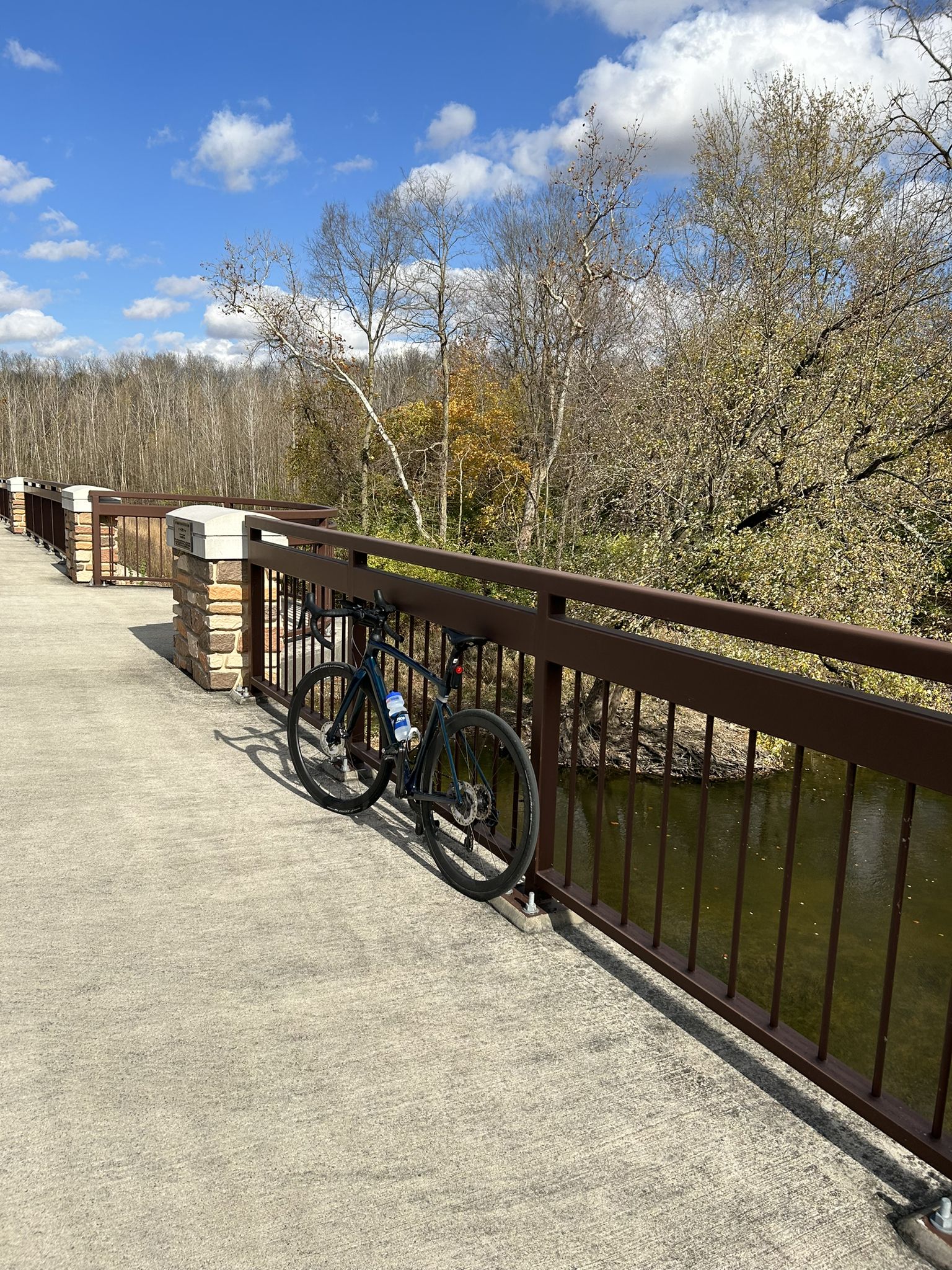 Bicycle on a bridge, water below, autumn trees, bright sunny day. - Troy loop from Troy