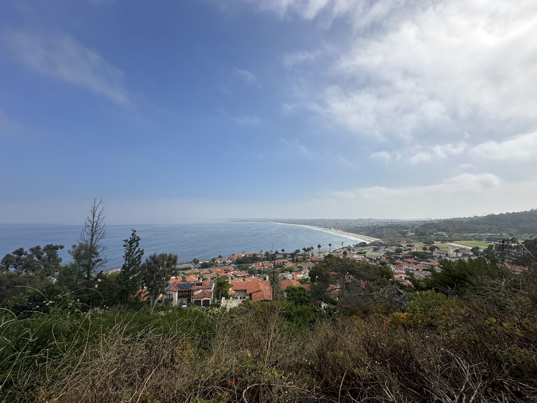 Panoramic view of a coastal town, beach, and ocean under a partly cloudy sky. - Point Vicente Lighthouse loop from Palos Verdes Estates