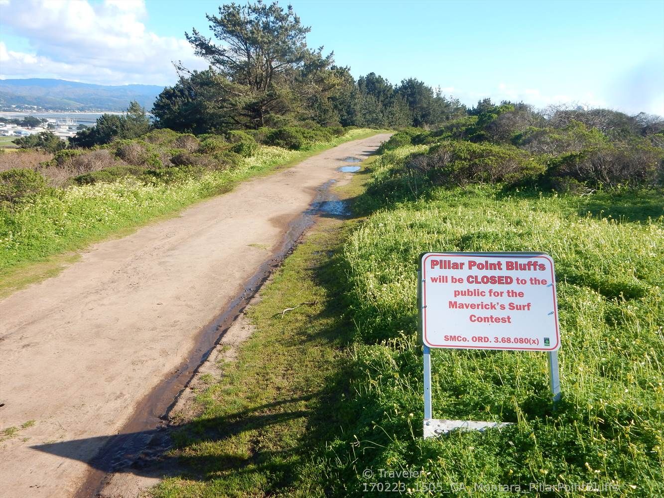 Dirt path through grassy hills with a white sign under a sunny sky. - Pillar Point Bluffs – Halfmoon Bay Brewery loop from El Granada