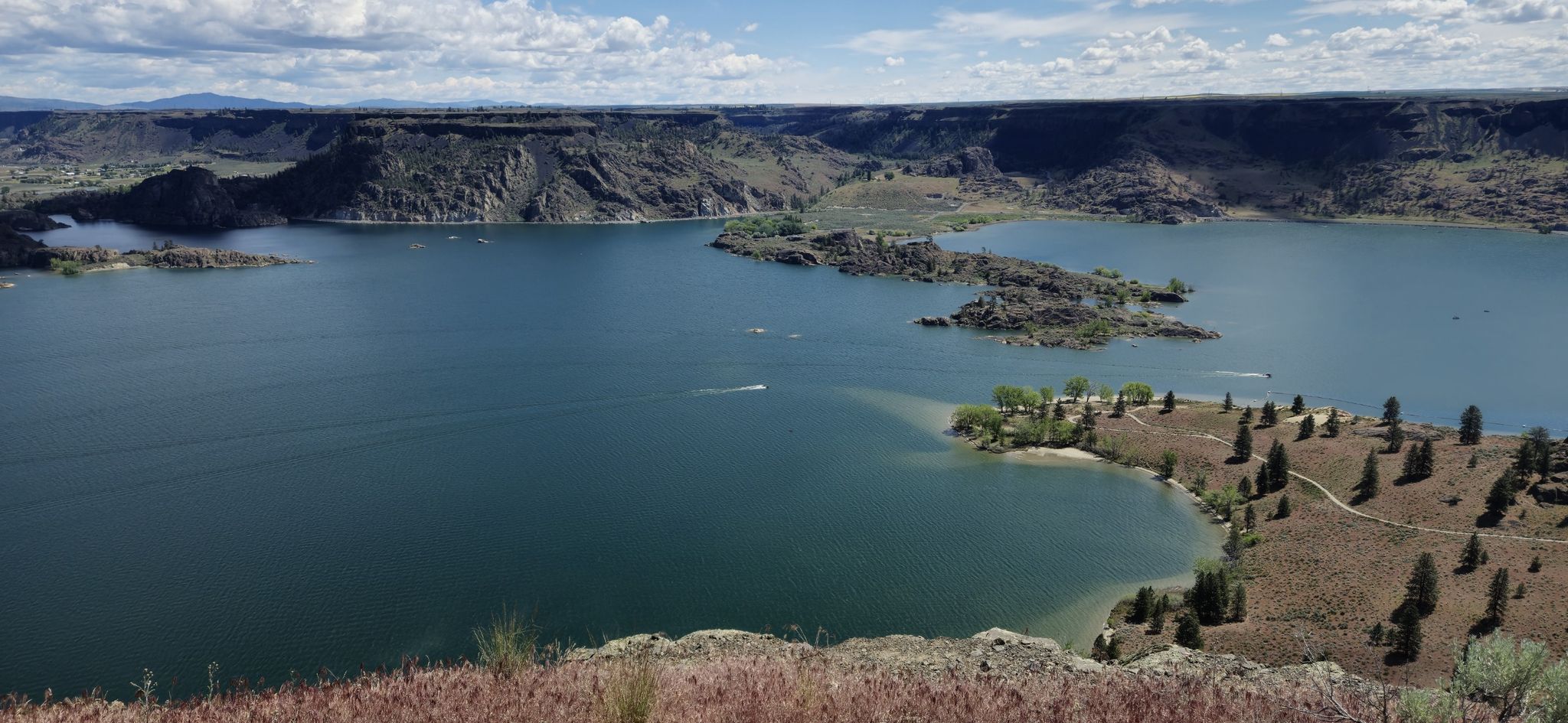 Expansive blue lake with several rocky islands and distant cliffs under a bright sky. - Steamboat Rock Trail loop from Cabin 2