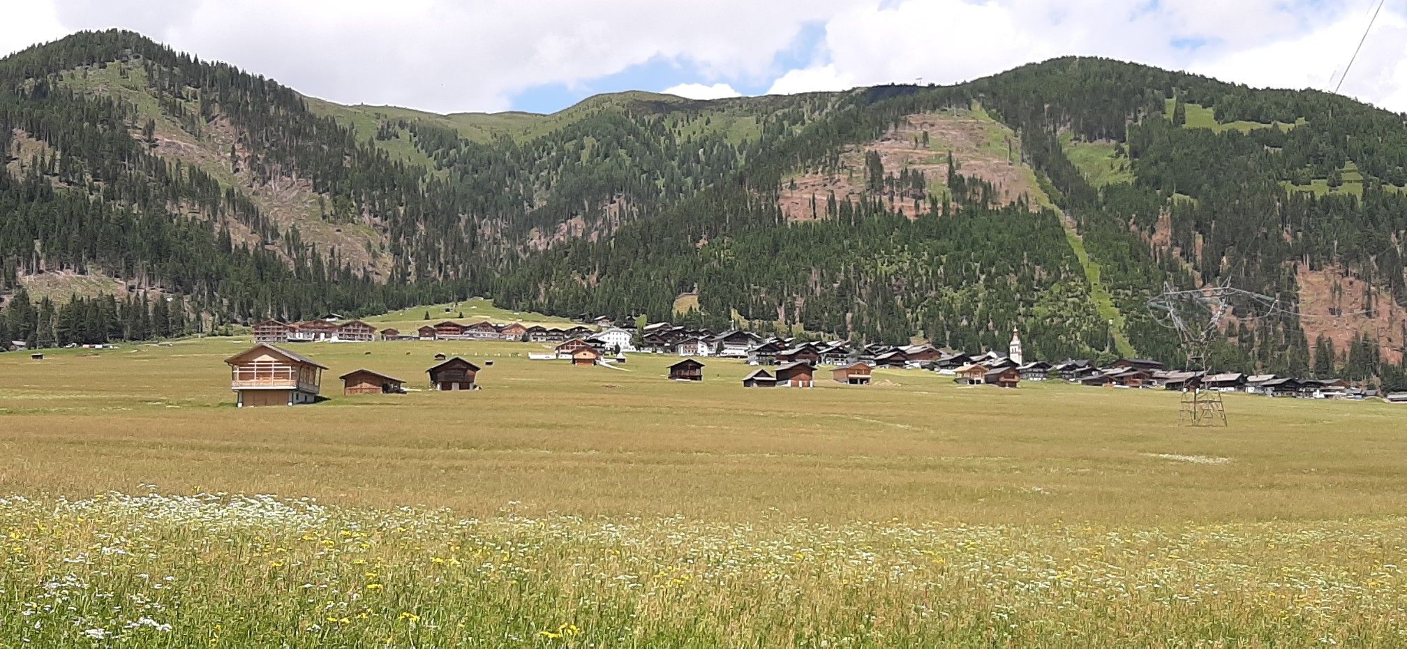 Blick zurück nach Obertilliach  -- im Vordergrund all die Heuschober  -- ganz links ein Neubau