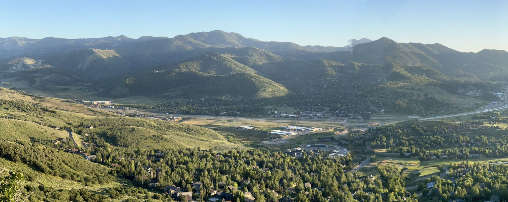 Panoramic view of a green valley surrounded by distant mountains under clear skies. - Beaver Pond – Stealth Trail loop from Awards bus stop