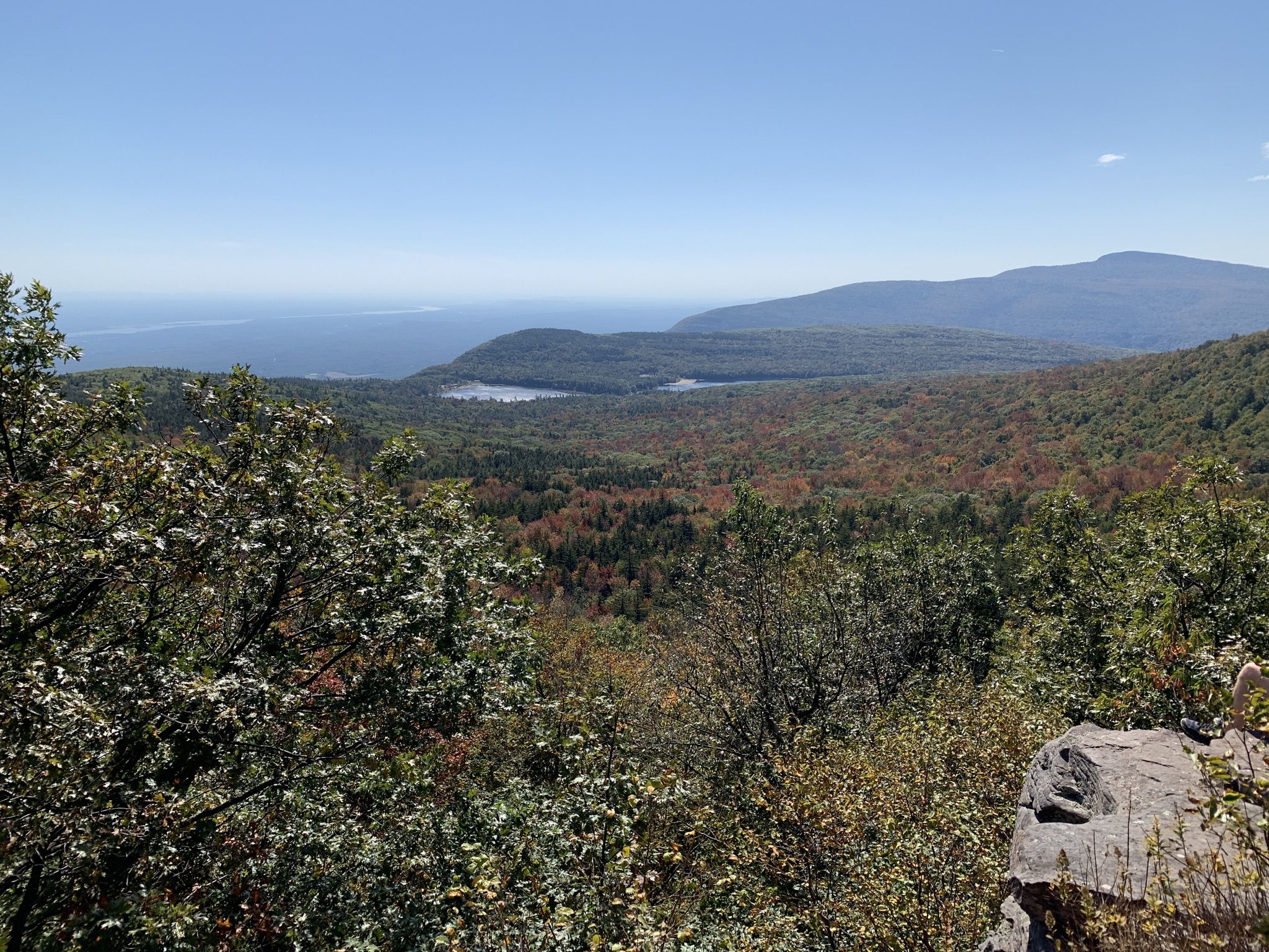 A mountain view with a distant lake, autumn trees, and a clear blue sky. - North Point and Badman's Cave Loop