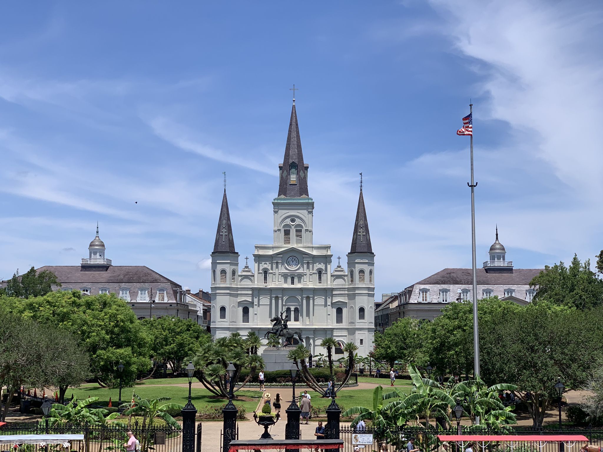 A grand cathedral with spires overlooks a green park under a bright blue sky. - Bayou St. John – Washington Artillery Park loop from Delgado Community College