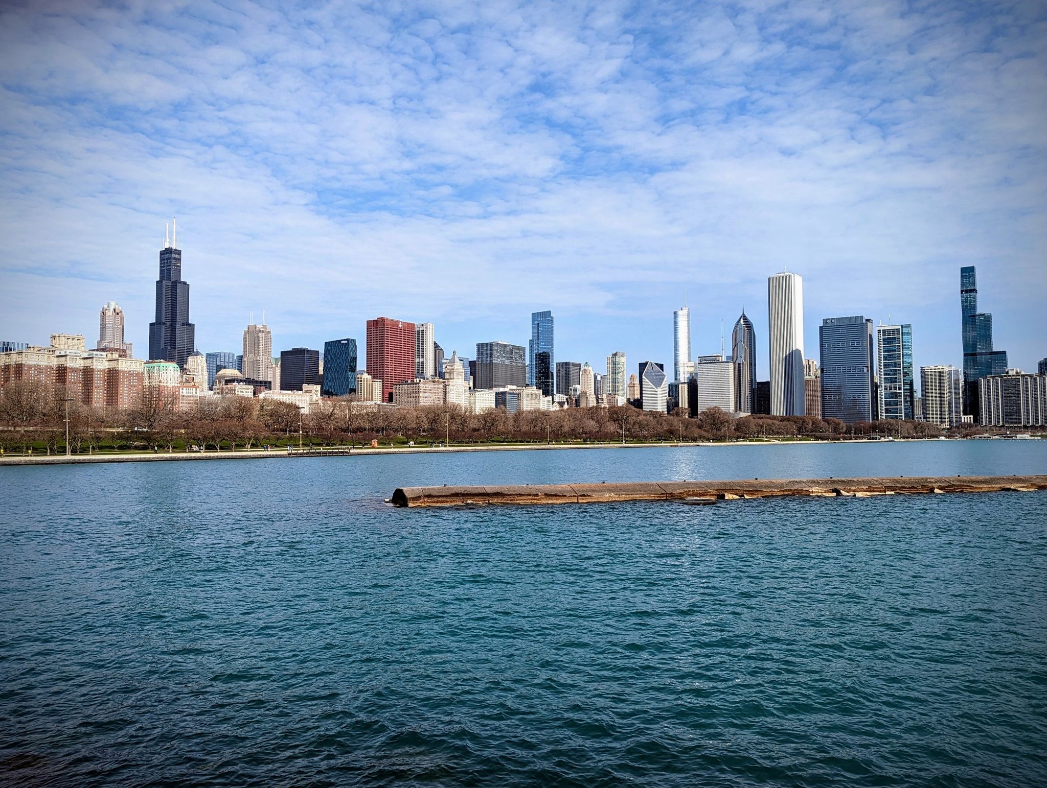 Wide body of water with a distant city skyline under partly cloudy sky. - Chicago Lakefront and Riverwalk Trail
