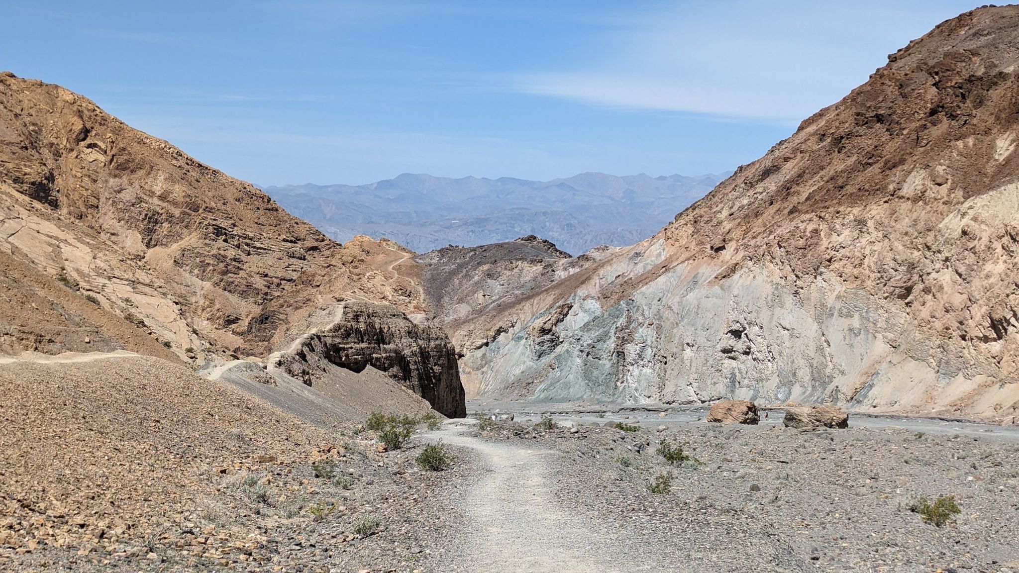 Desert trail winding through a wide valley with colorful, rocky mountains. - Green Marble Walls – Mosaic Canyon Trail loop from Mosaic Canyon Trailhead