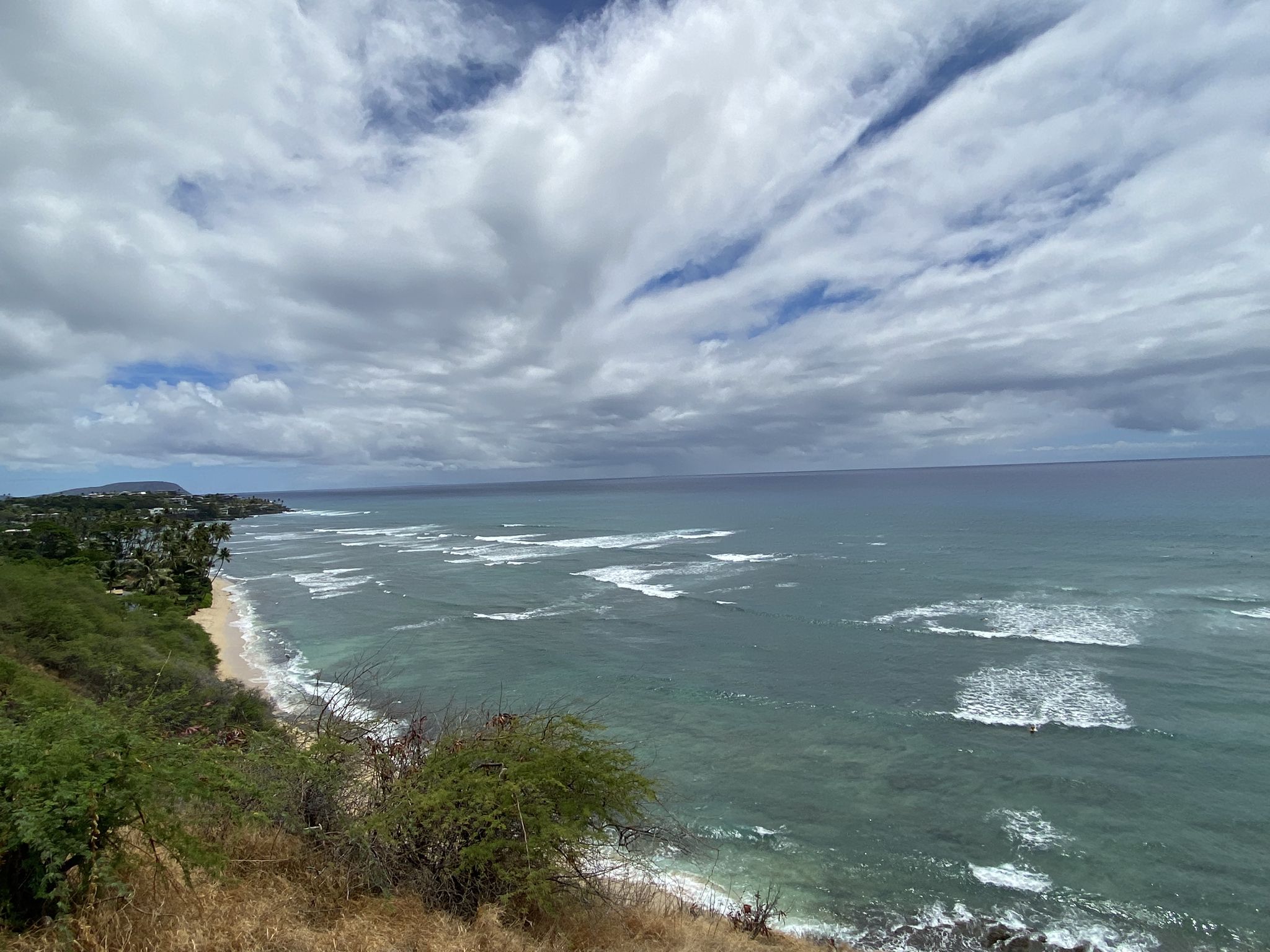 Ocean waves crashing on a green coastline under a cloudy sky. - Makapu'u via Pearl City