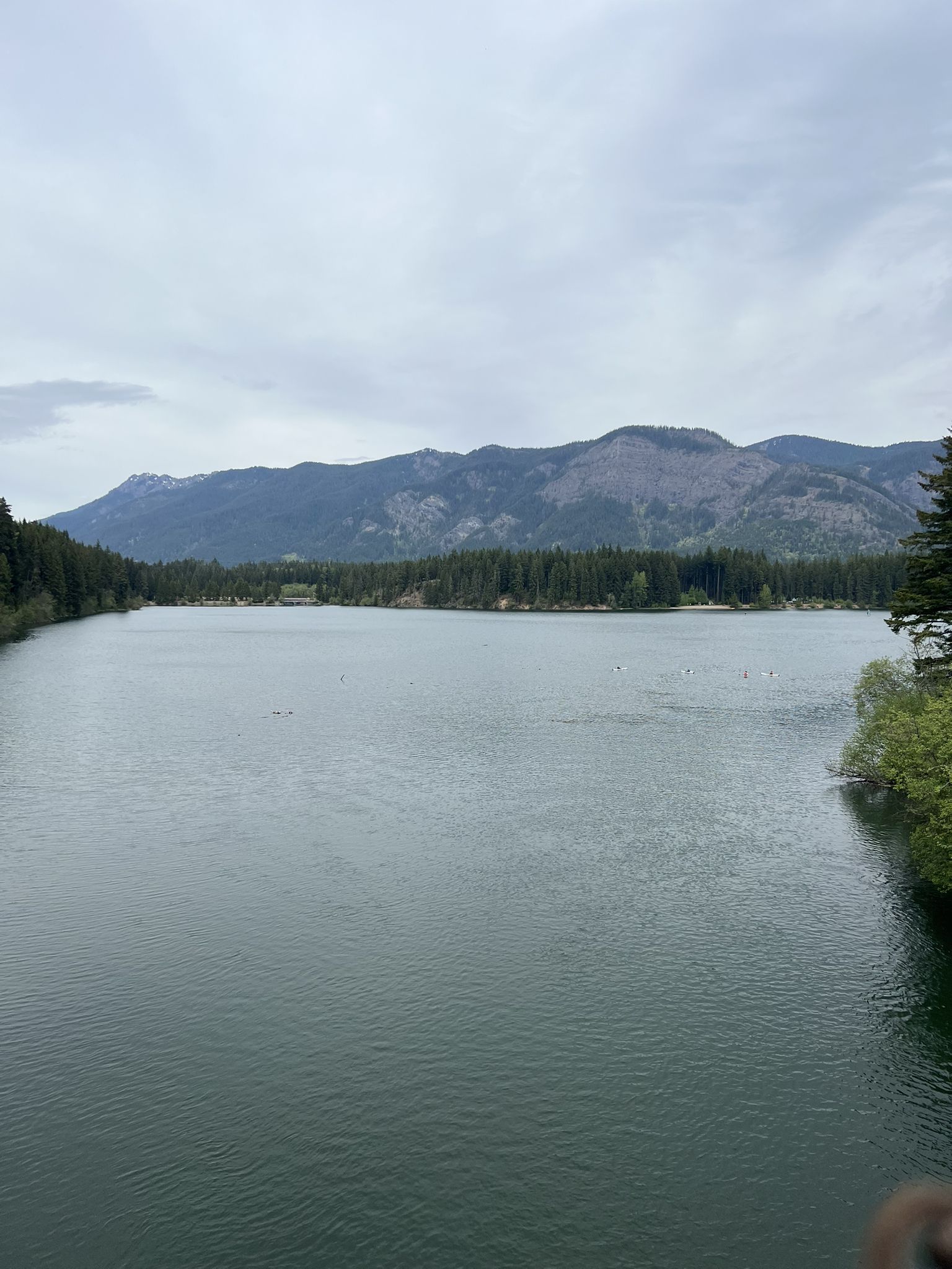 Wide lake with forested shores and mountains under an overcast sky. - View of Lake Easton – Lake Easton State Park loop from Easton State Airport