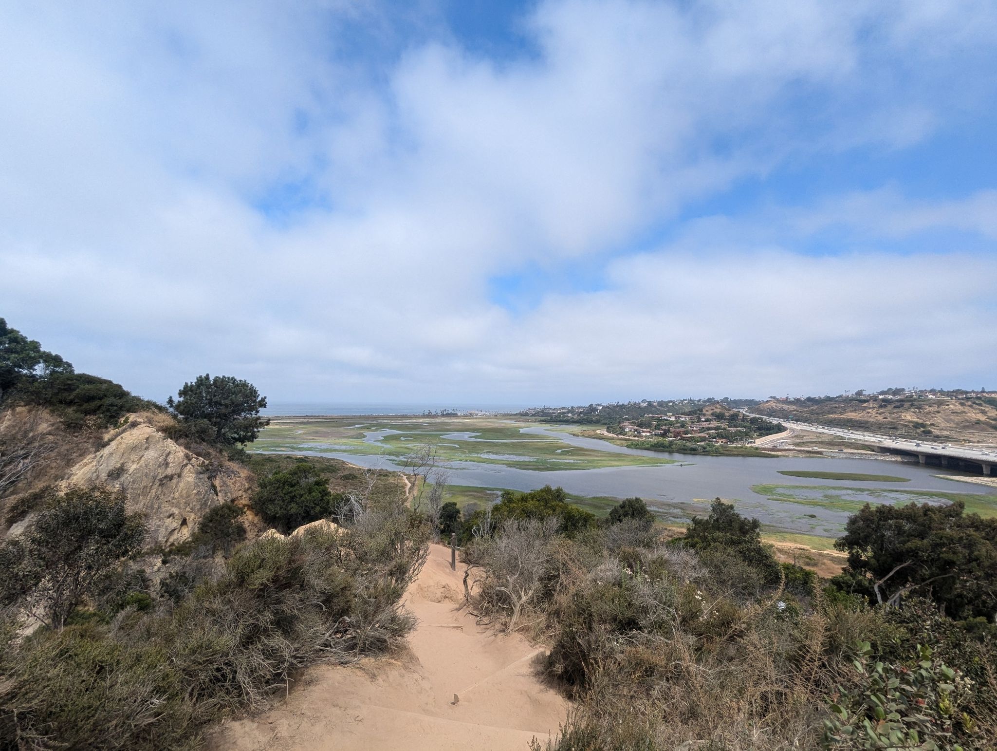 Overlook of a wetland estuary with a path, under a cloudy sky. - Rios Avenue Trail – Annie's Canyon loop from Solana Beach