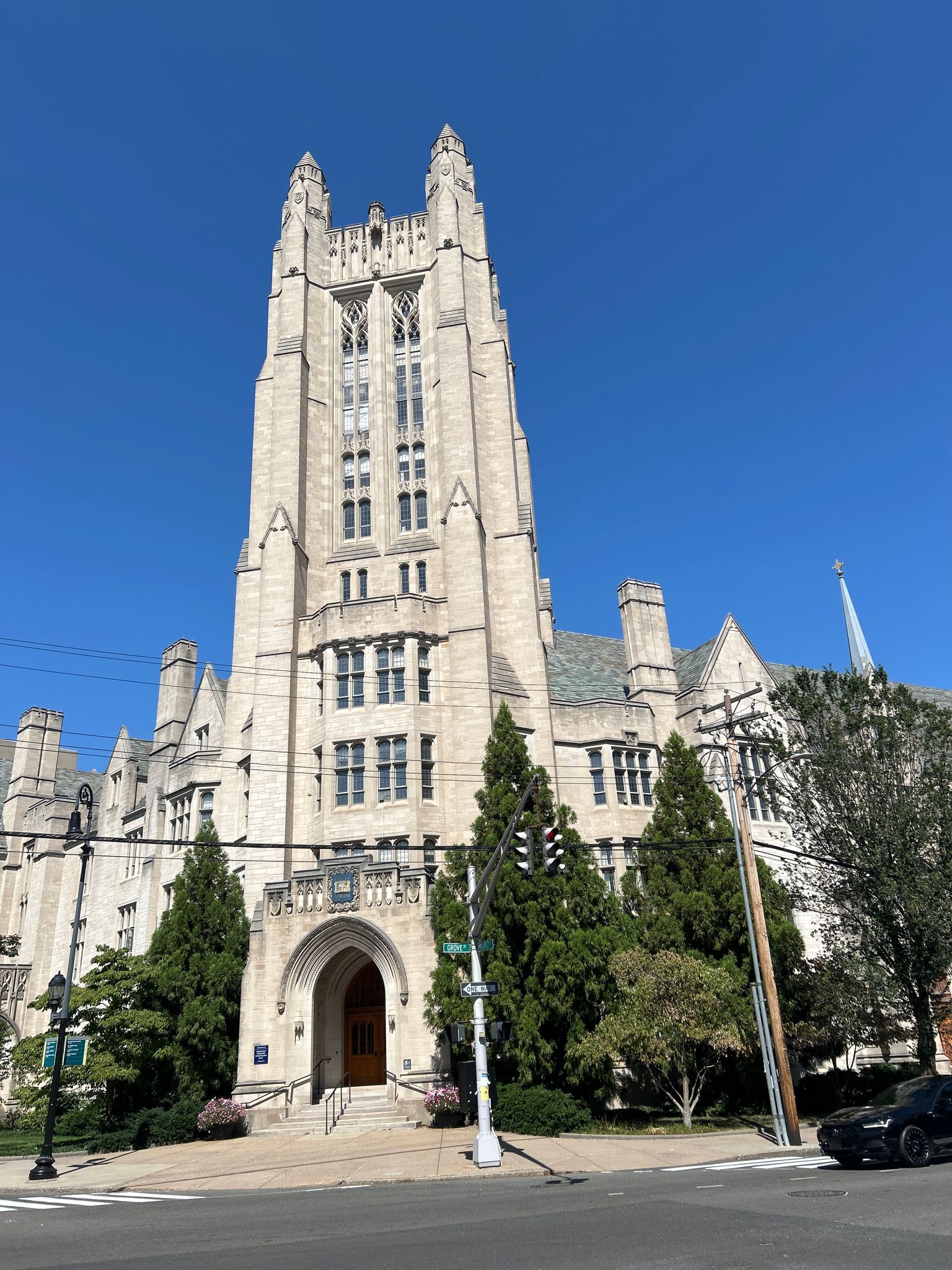Grand stone building with a tall, ornate tower under a clear blue sky. - Bass Tower loop from Congregation Mishkan Israel