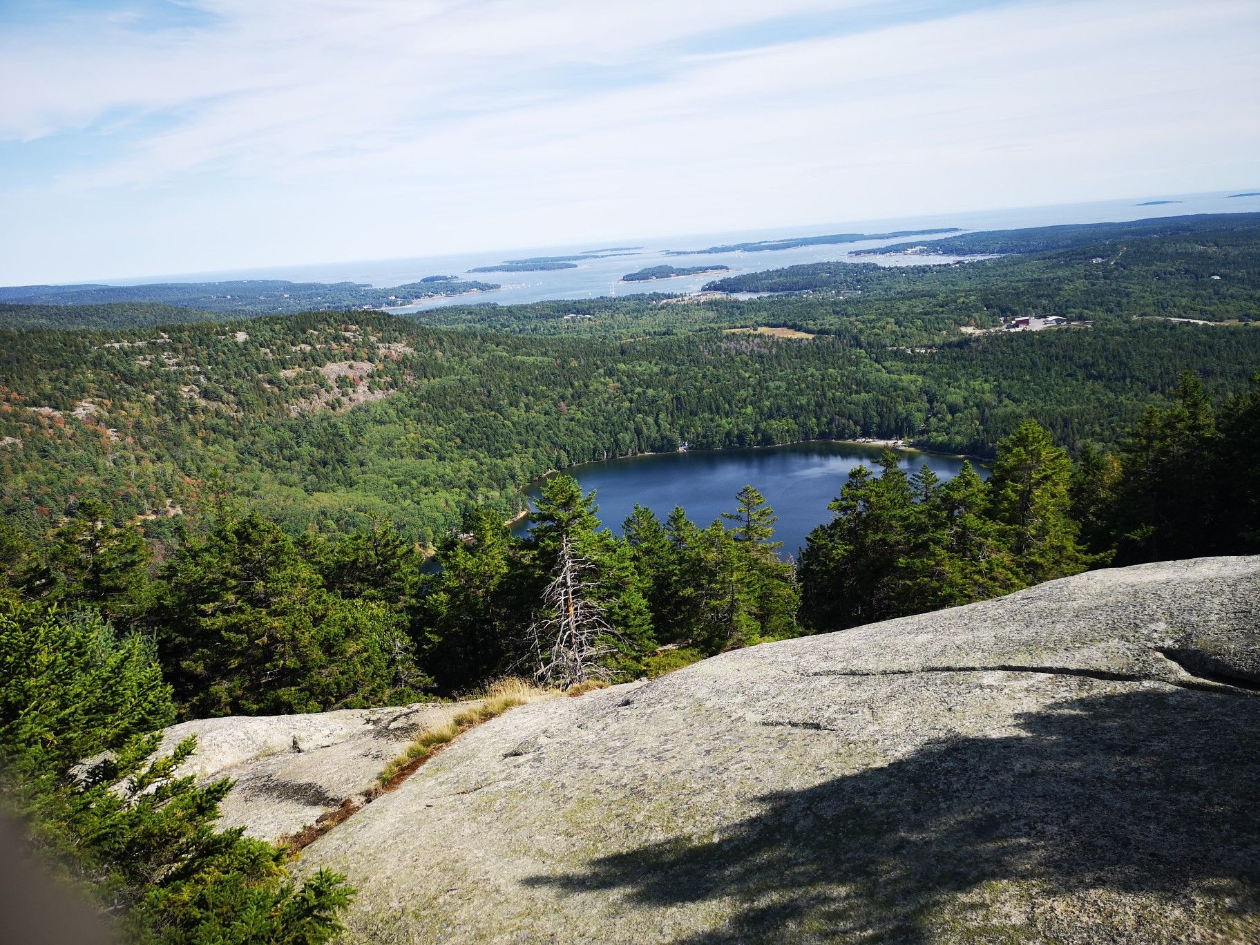 Sunny panoramic view of a lake, forested hills, and distant ocean. - Perpendicular and Razorback Loop