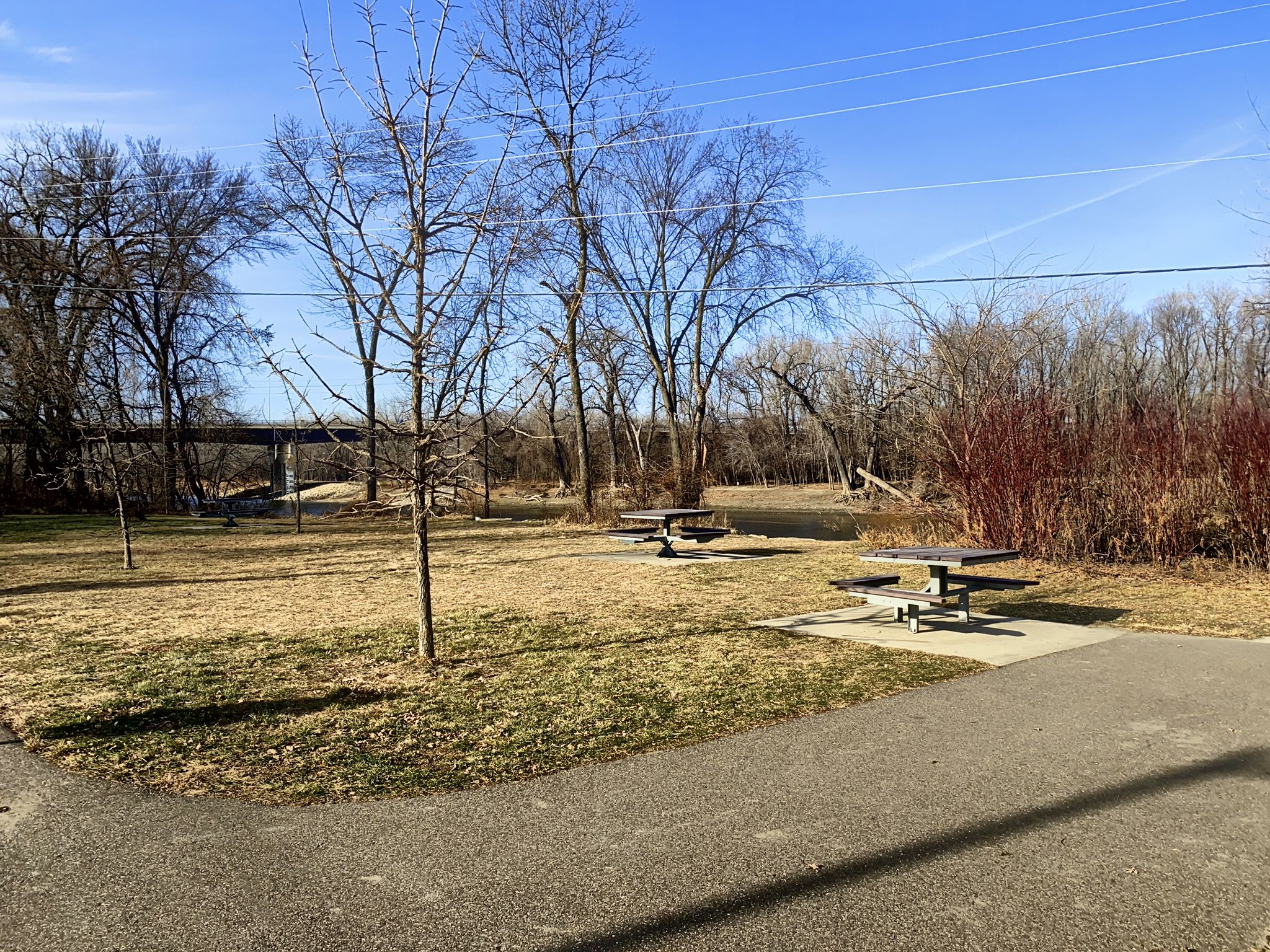 Picnic tables on a grassy field with bare trees and a paved path. - Black Dog Lake – Black Dog Lake loop from Burnsville